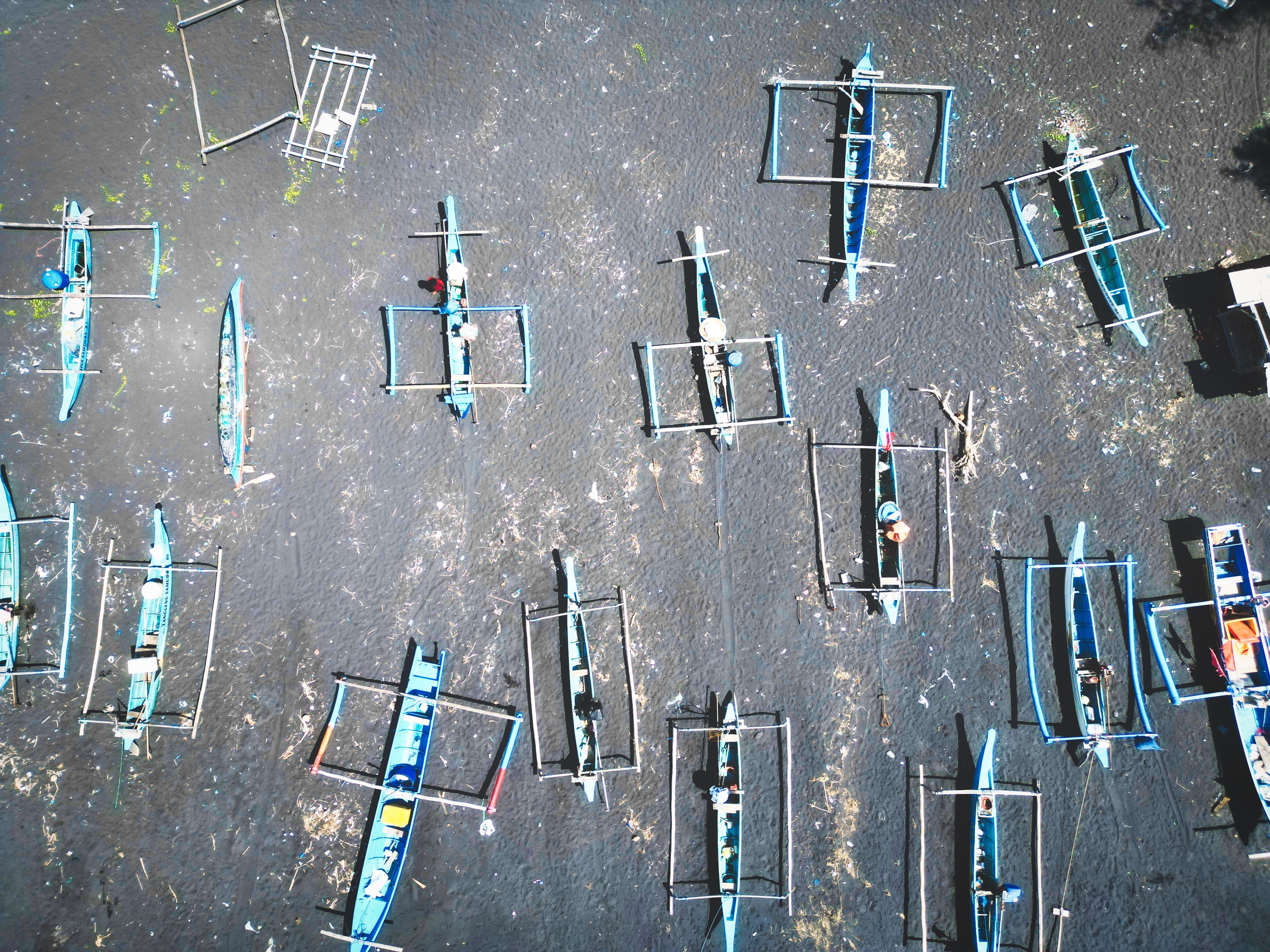 Aerial shot of traditional fishing boats in Bali, Indonesia, showcasing a vibrant maritime scene.