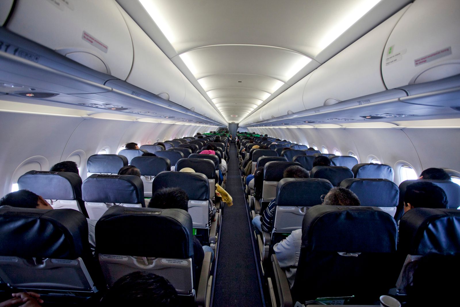 Passenger view down the aisle of a commercial airplane cabin