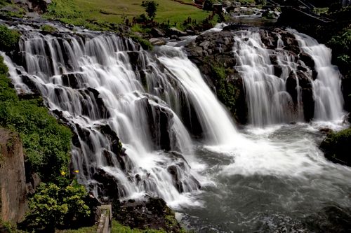 Free Captivating waterfall cascading over rocks surrounded by lush greenery, ideal for nature and travel themes. Stock Photo