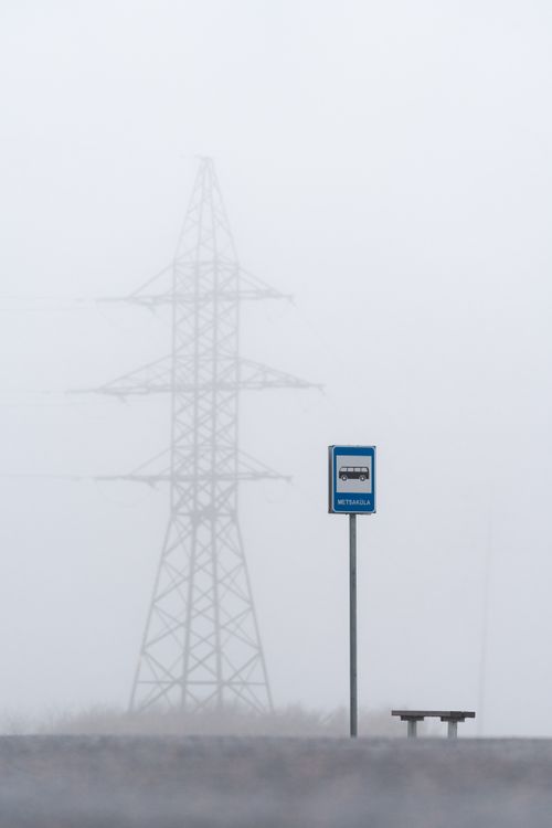 Free A serene foggy bus stop with power lines in the background, capturing a mystical and quiet morning scene. Stock Photo