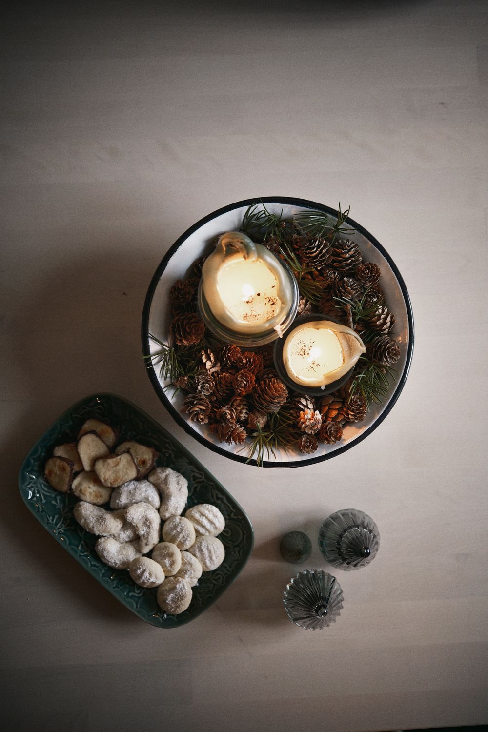 Winter flat lay with candles, pinecones and powdered cookies — Michael Obstoj on Pexels