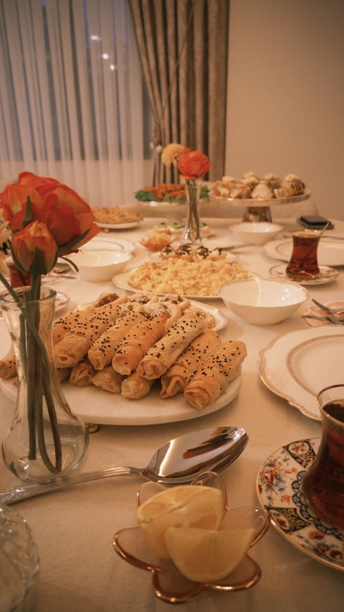 Free Elegant dinner table with pastries, flowers, and Turkish tea, ideal for festive gatherings. Stock Photo