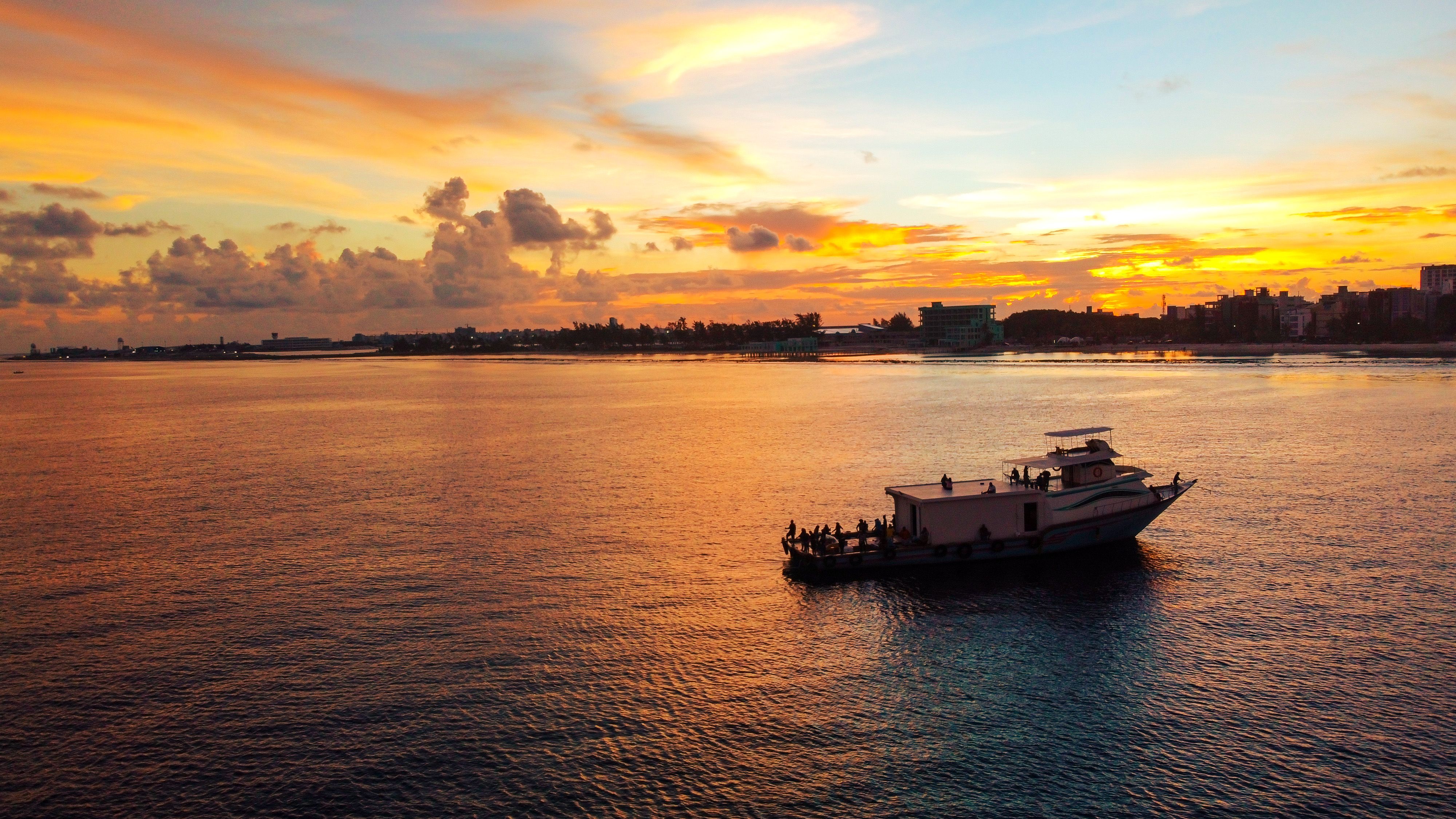 Serene sunset view of a fishing boat in Malé, Maldives, perfect for travel inspiration. - Hulhumalé