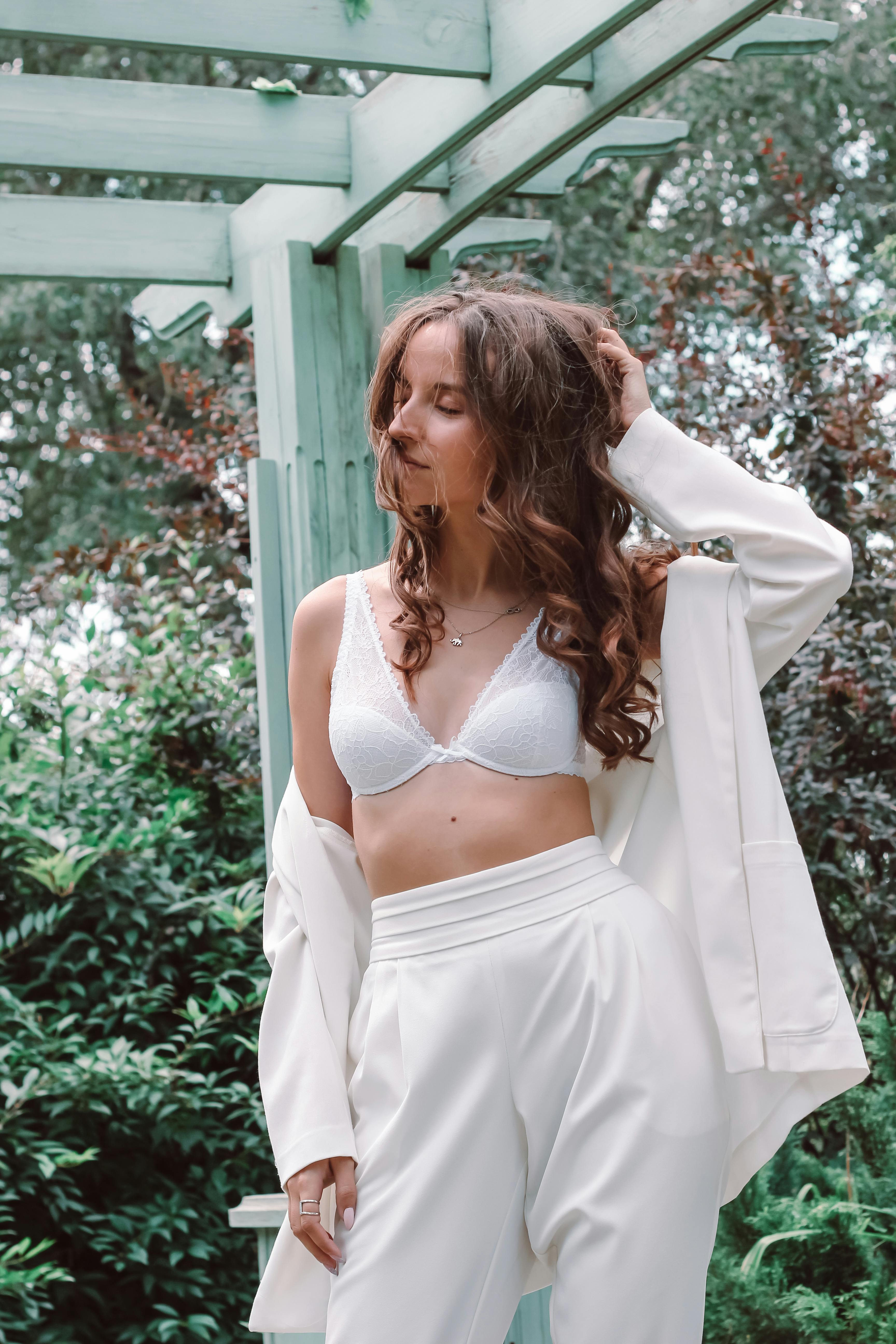 Kostenlos Frau Im Weißen Büstenhalter Und Im Weißen Rock, Die Nahe Grünen Pflanzen Stehen Stock-Foto