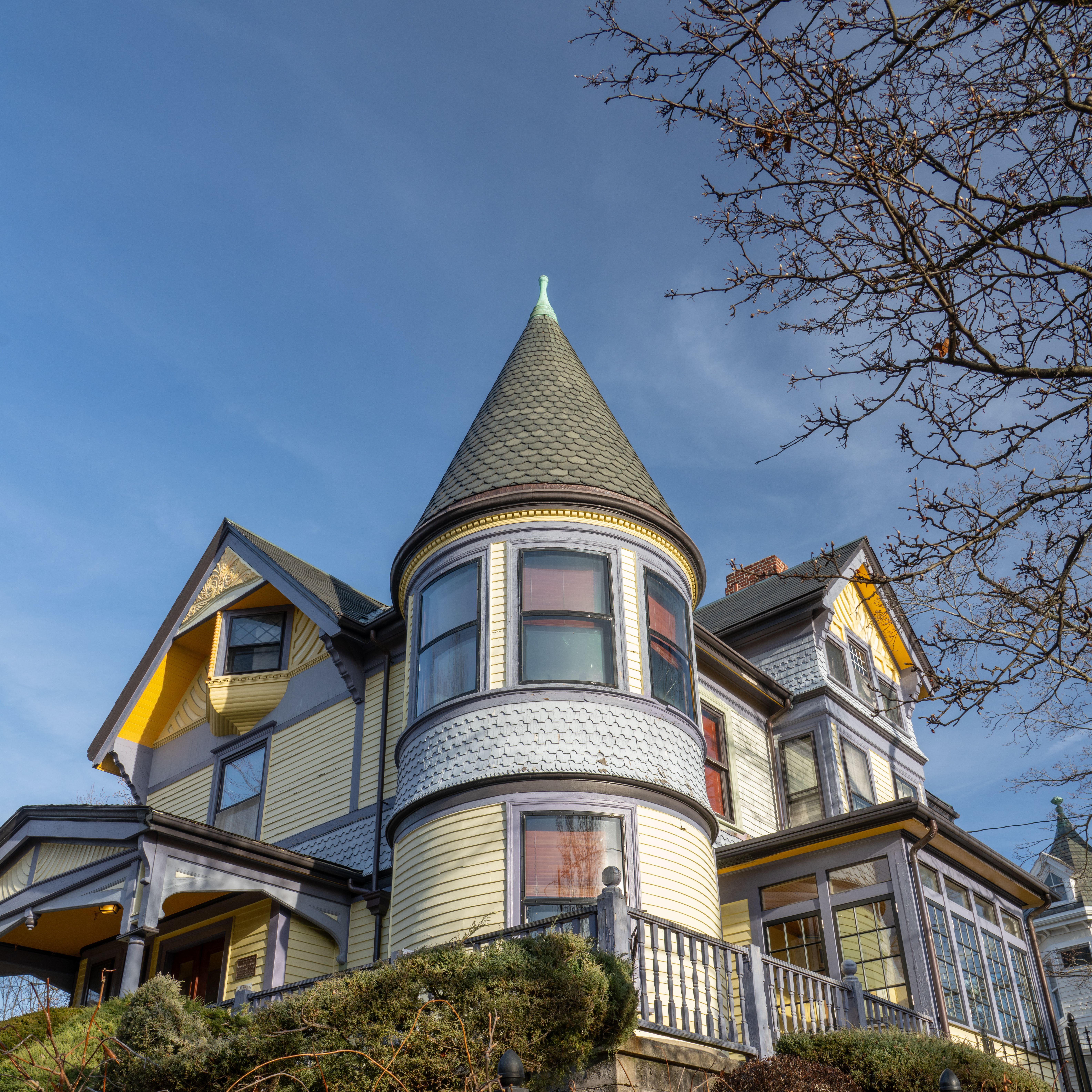 Elegant Victorian-style house with a turret and intricate design against a clear sky.
