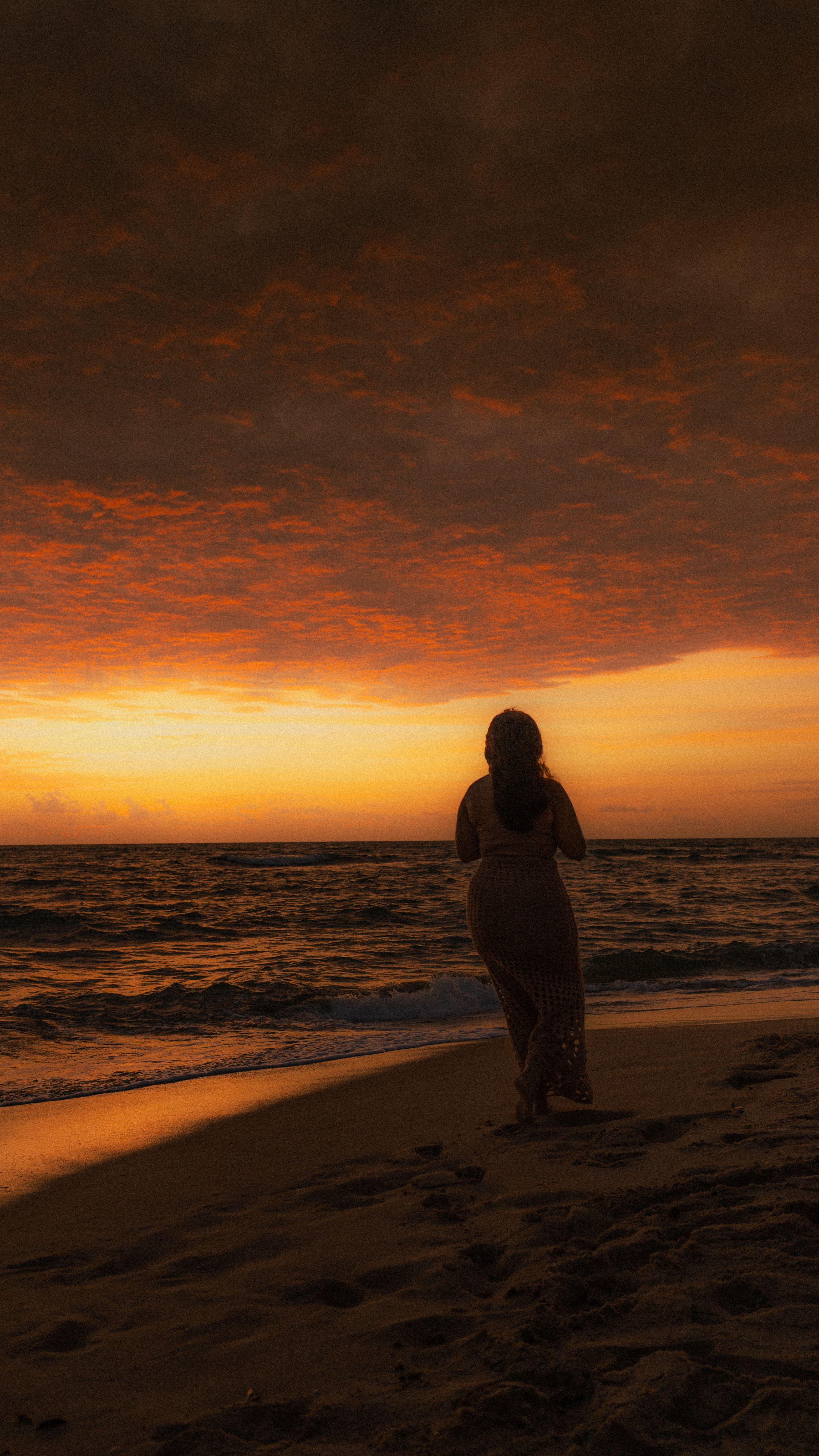 Silhouette of Woman on Beach at Dramatic Sunset · Free Stock Photo