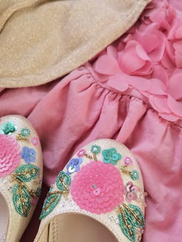 Charming pink outfit featuring embellished shoes and a floral dress, perfect for special occasions.