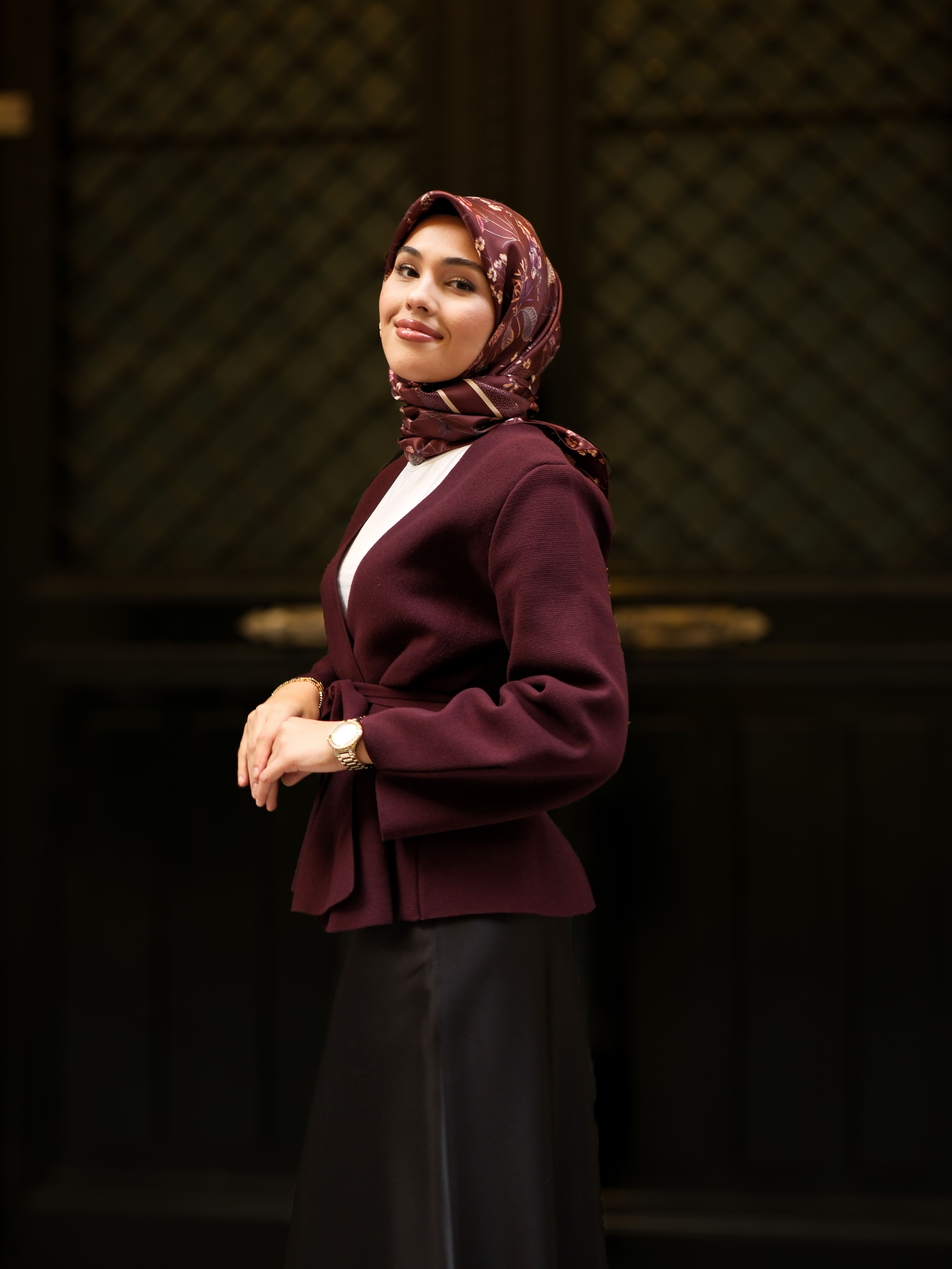 Woman in a burgundy blazer with a cream top