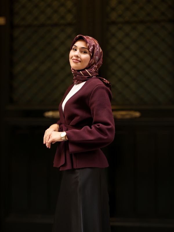 Woman in a burgundy blazer with a cream top