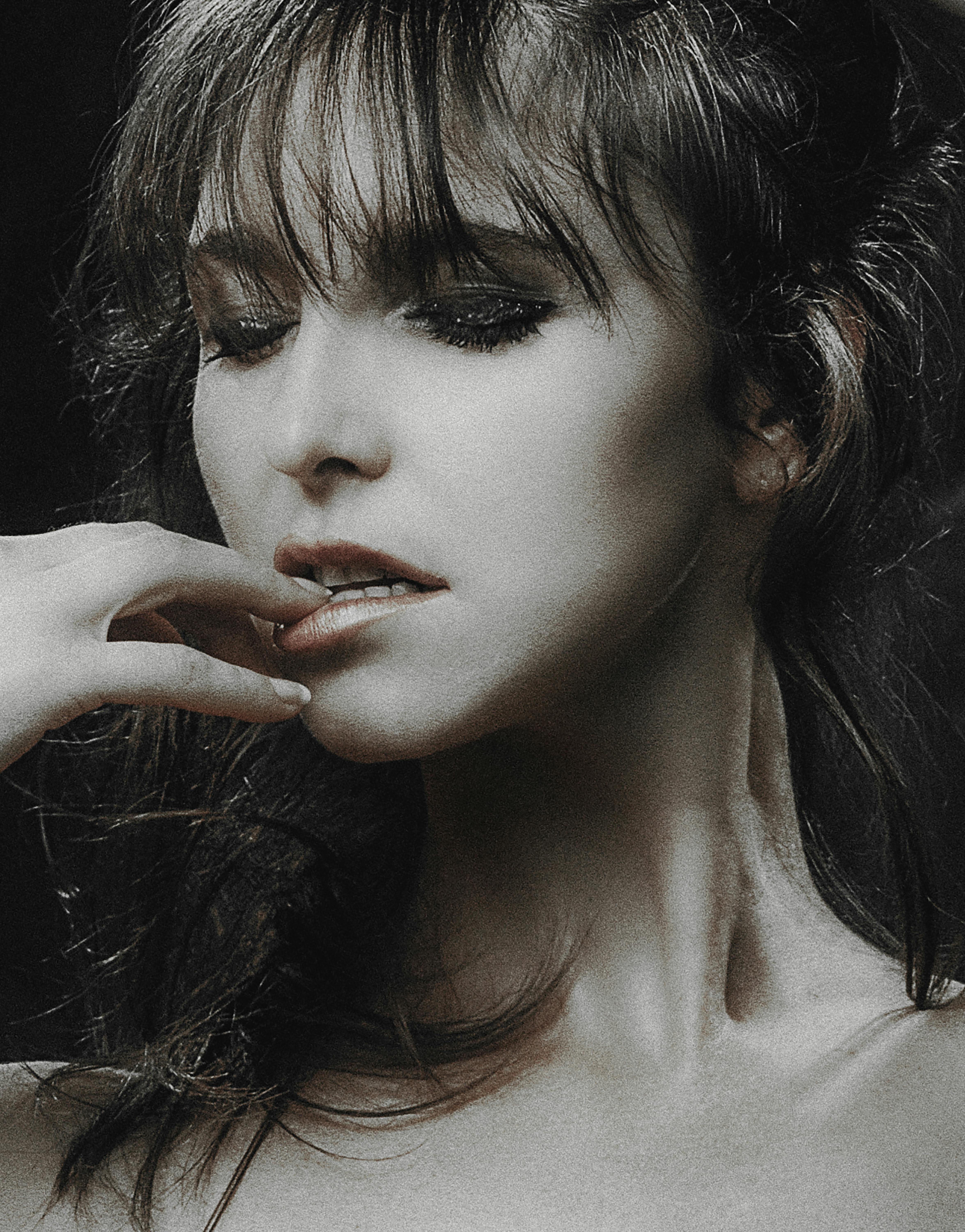 Artistic close-up black and white portrait of a woman with dramatic lighting and expression.