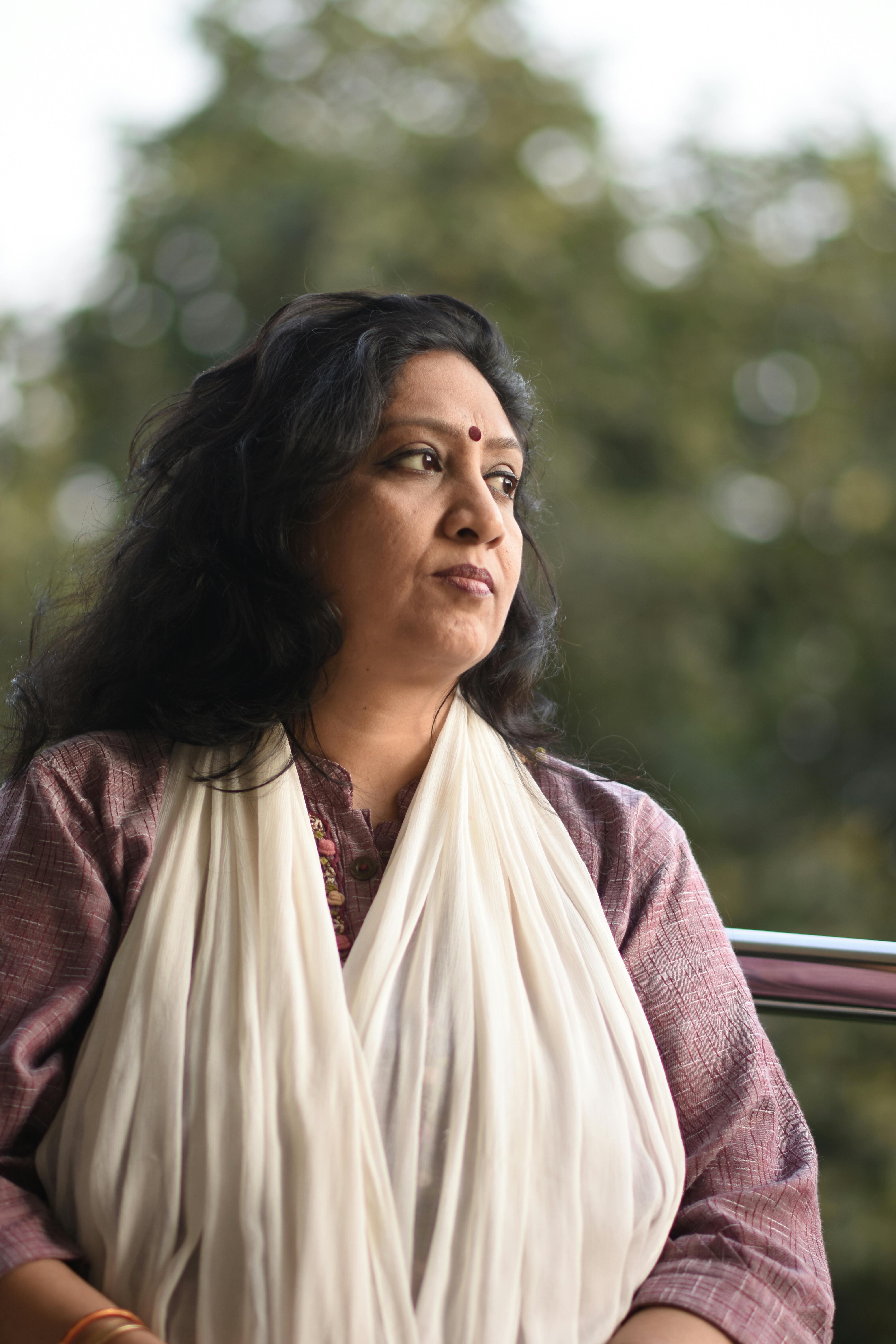 Portrait of a thoughtful woman in traditional Indian attire outdoors.