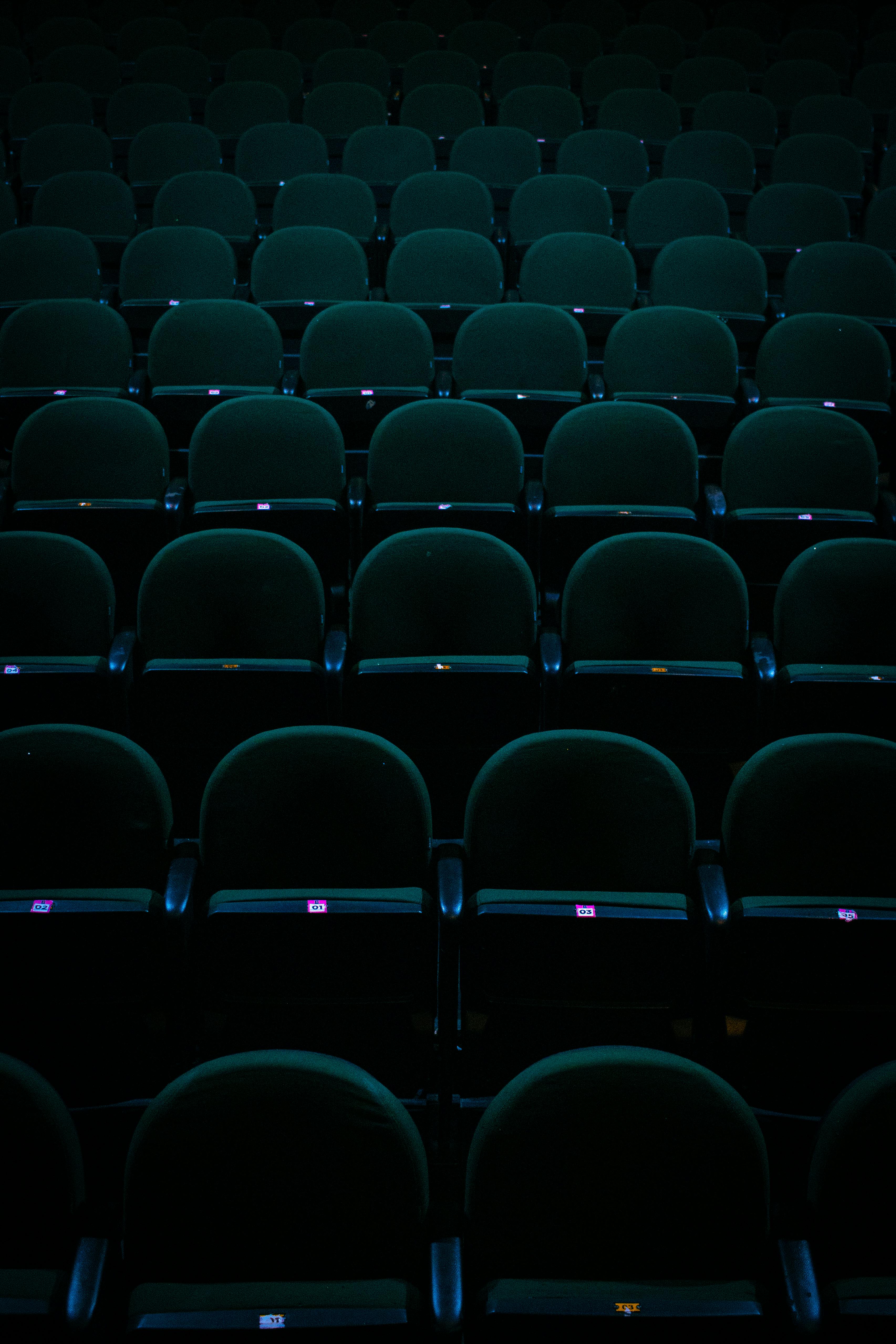 De franc Una filera de seients de teatre de color verd fosc en un auditori amb poca llum a Mauá, SP, Brasil. Foto d'estoc