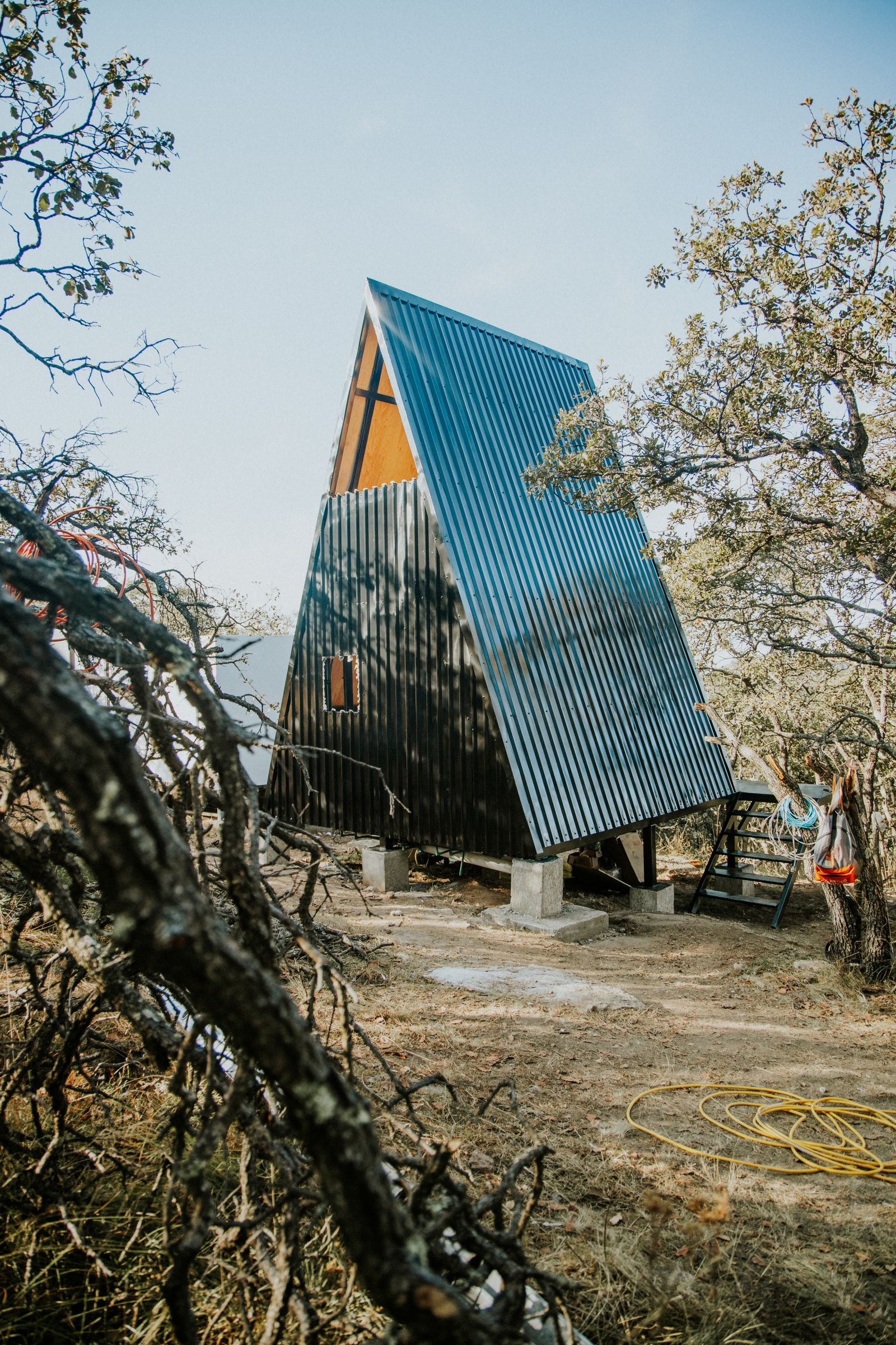 Modern A-frame cabin surrounded by evergreen forest in the Pacific Northwest