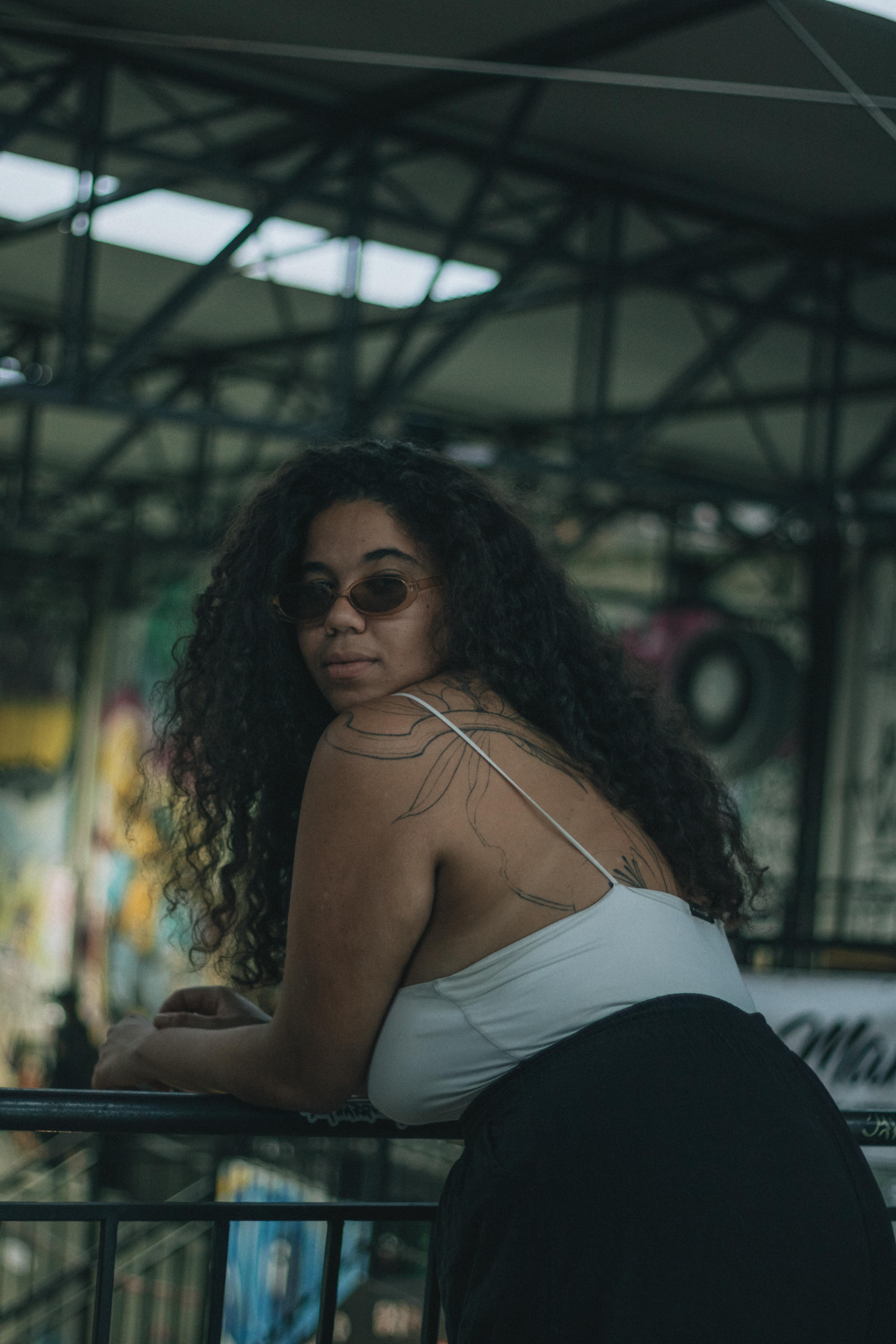 De franc Dona elegant amb tatuatges posa en un entorn artístic i industrial. Perfecte per a temes d'estil de vida urbà. Foto d'estoc