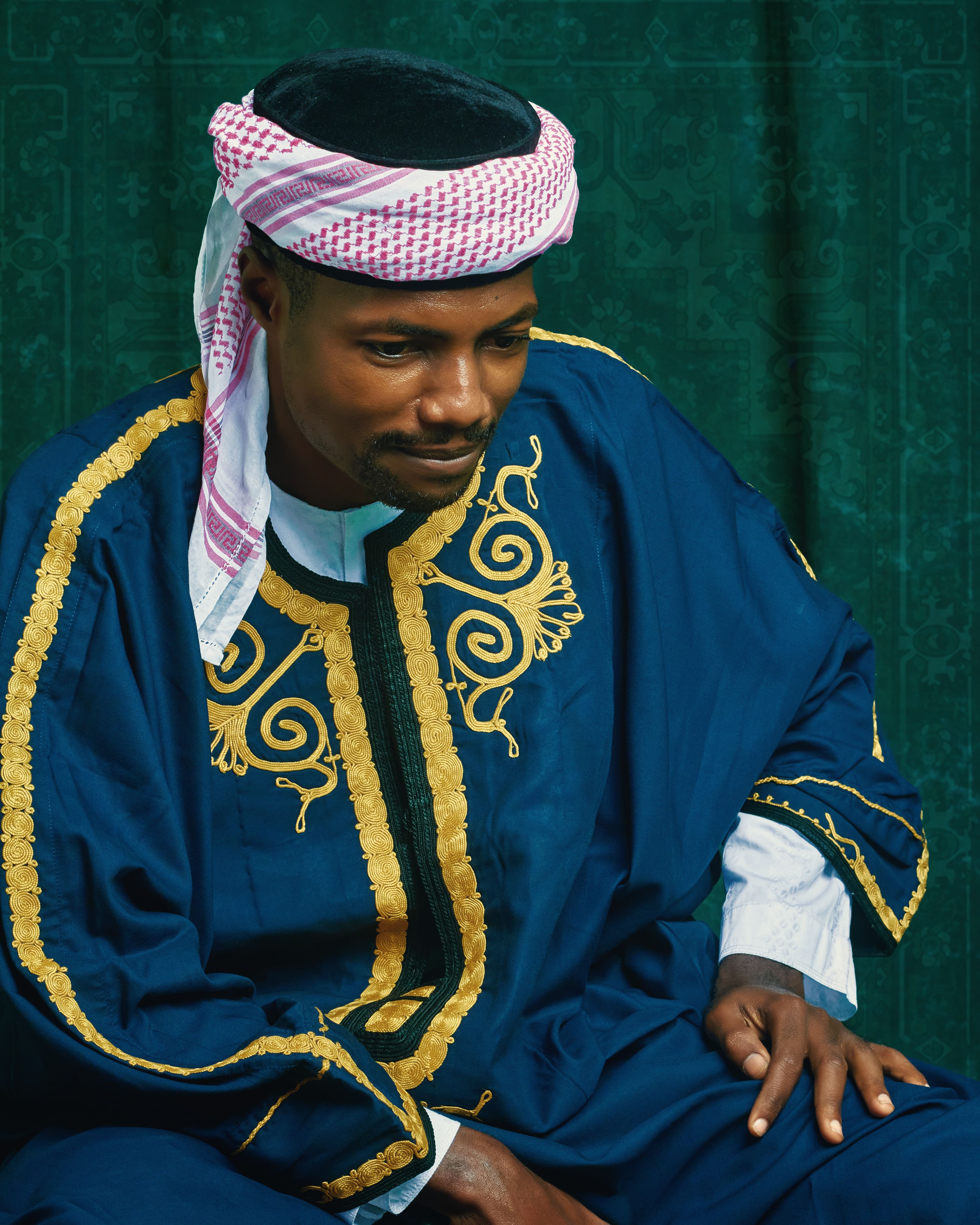 Portrait of a man wearing traditional Middle Eastern clothing with intricate embroidery.