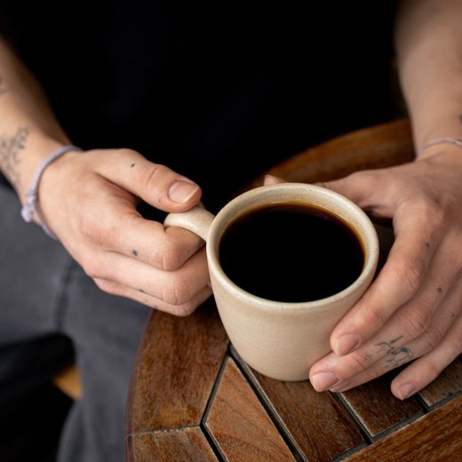 Hands cradling a sand-glaze ceramic tumbler — photo by Göksun Barış Gökalp on Pexels