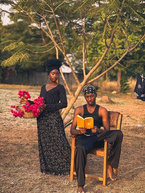 Two adults enjoy a serene outdoor moment with nature and vibrant flowers.