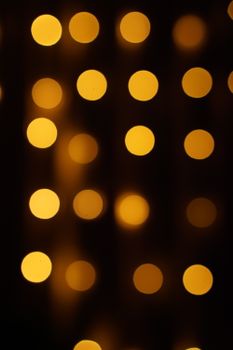 Abstract image of warm glowing bokeh light circles in a dark setting.