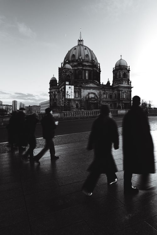 Free People walk past the Berlin Cathedral in a moody black and white scene. Stock Photo