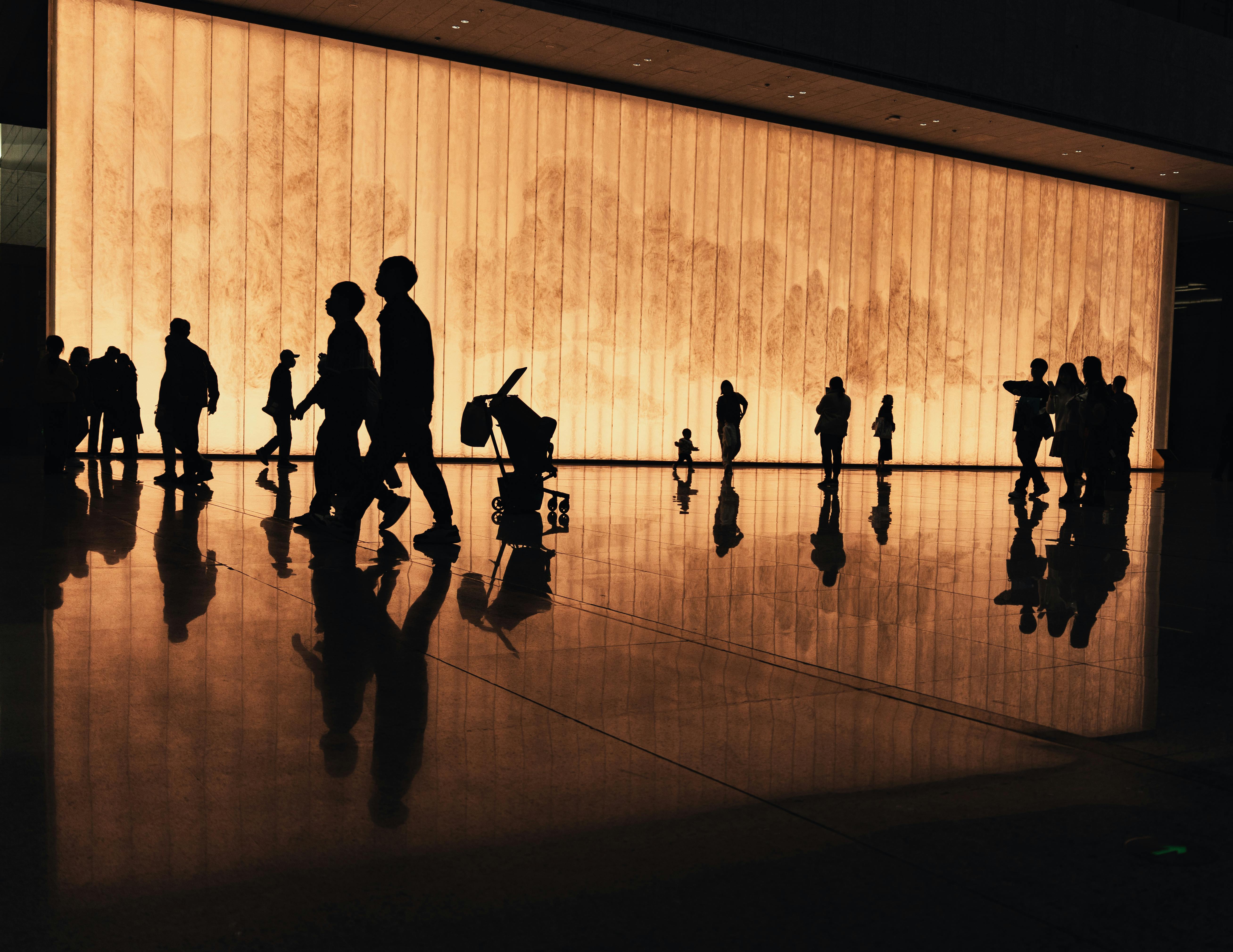 A diverse group of families walking into a modern church building with warm lighting and smiles