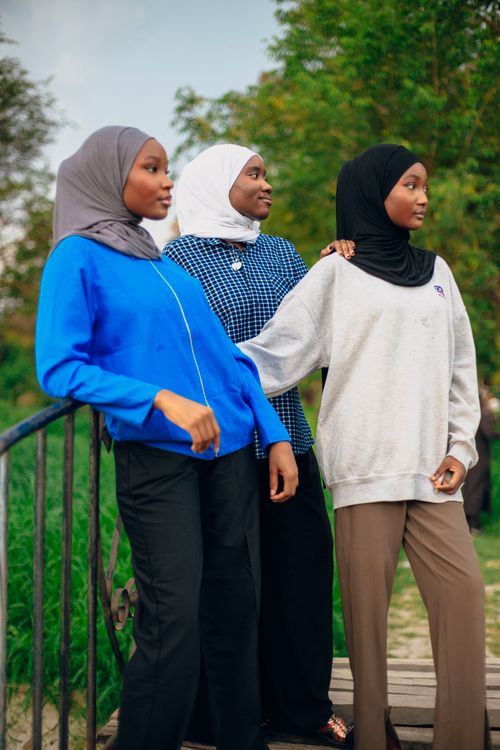 Free Three women wearing hijabs, enjoying a walk outdoors surrounded by greenery. Stock Photo