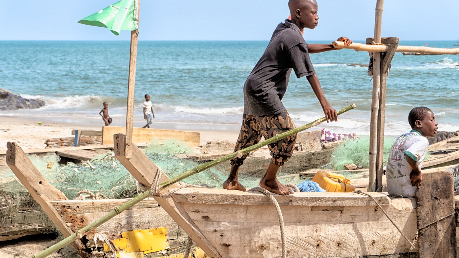 Boy with wooden boats on sea shore, Ghana