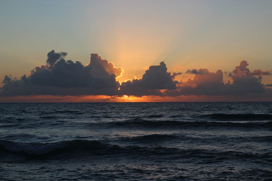 Sunrise breaking through cloud over the sea