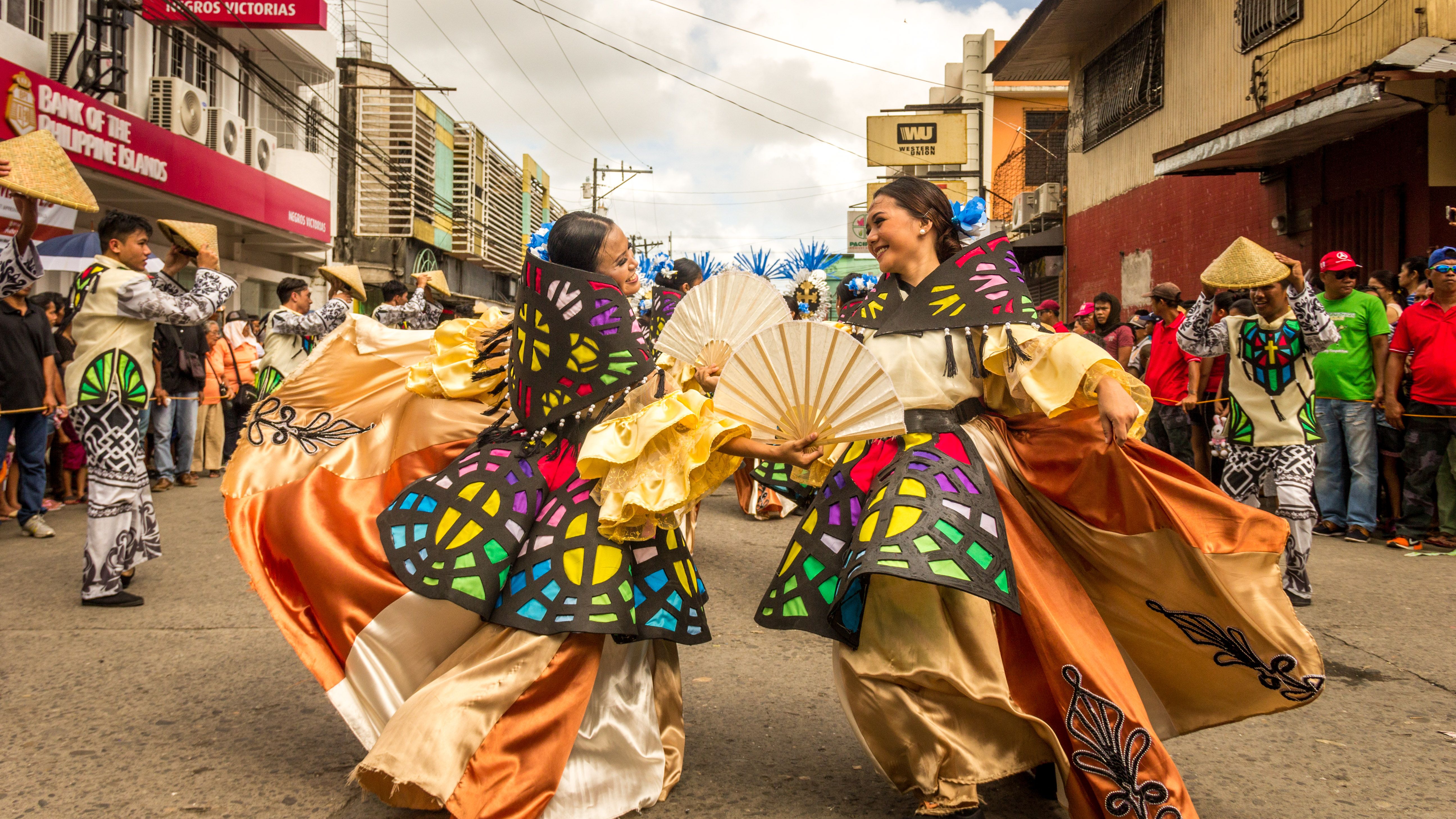 Vibrant street festival with dancers in traditional attire showcasing Filipino culture.