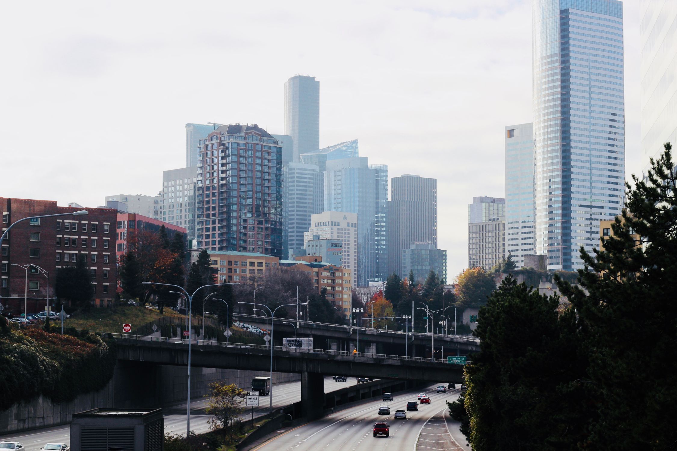 Seattle skyline view with tall skyscrapers and a busy highway below, showcasing urban life.