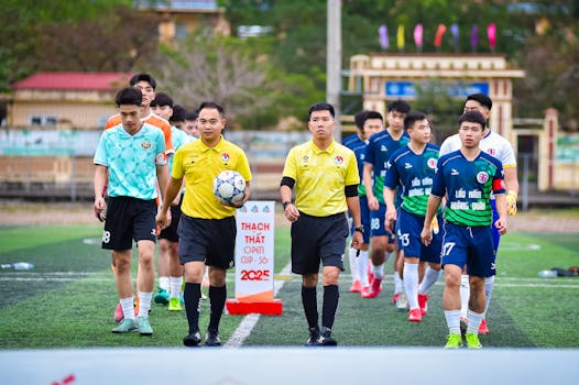 Football teams with referees walking onto the field in Hà Nội, Vietnam.