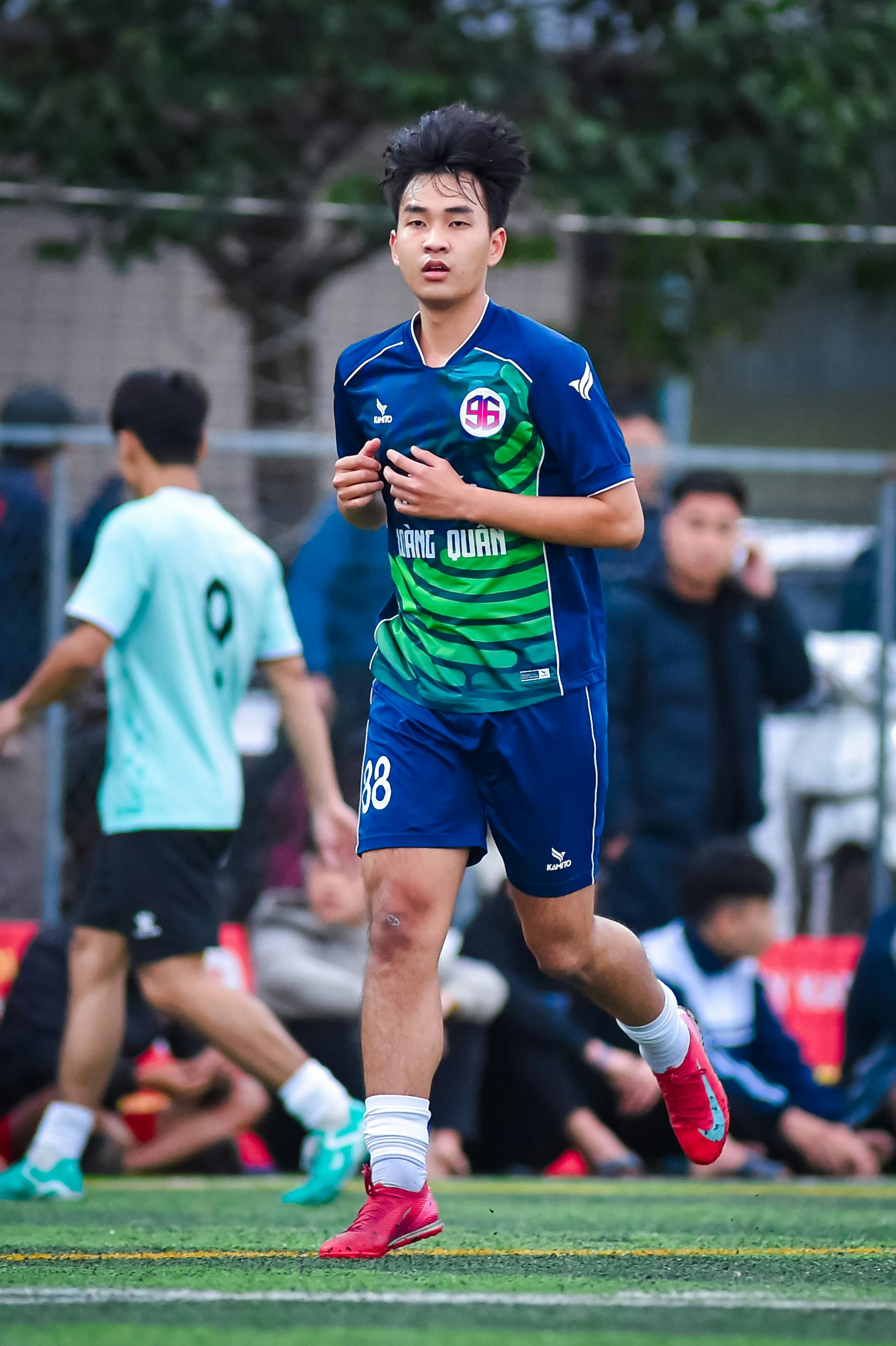 Young football player in action on a field in Hanoi, showcasing teamwork and sportsmanship.