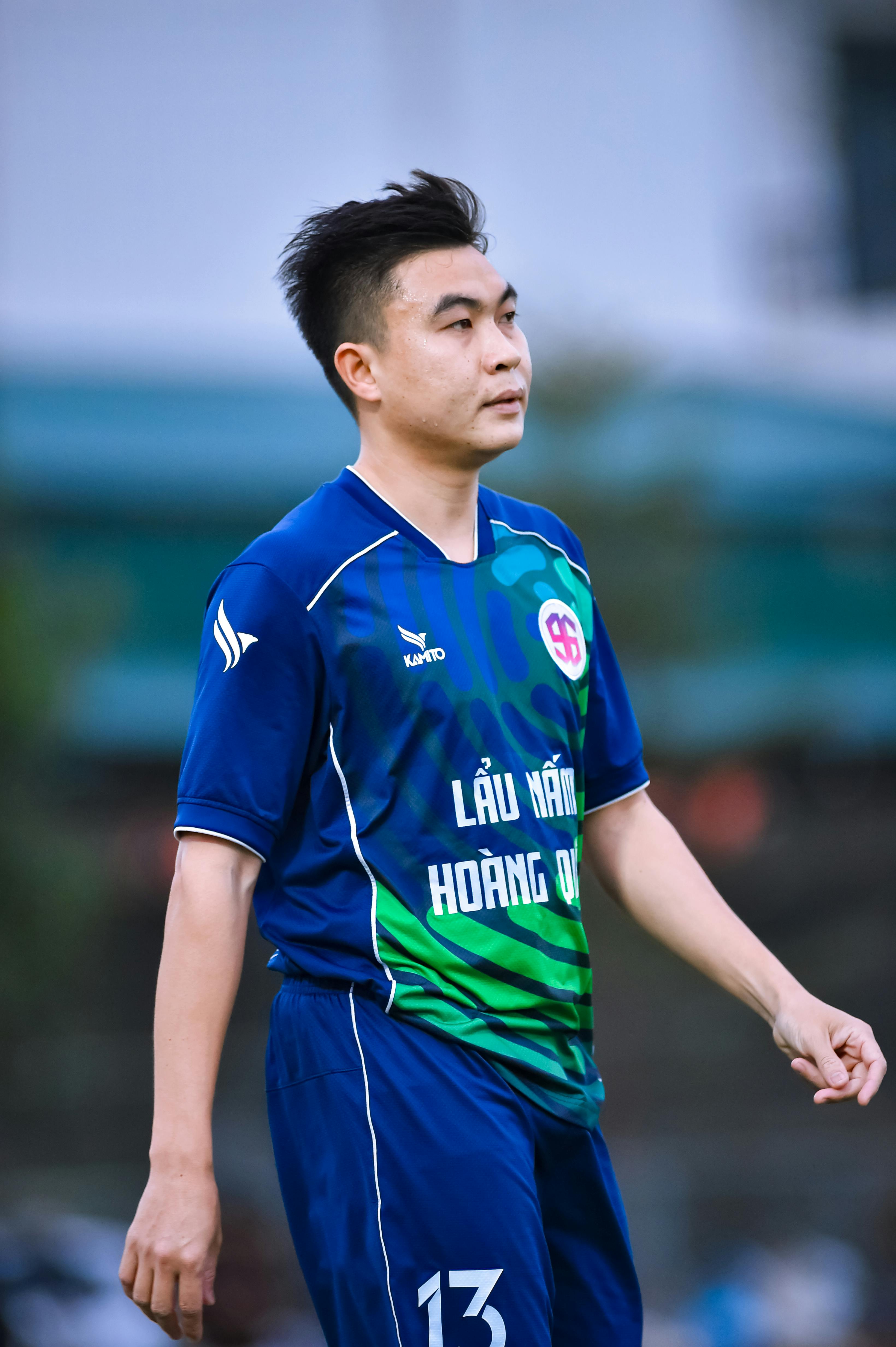 Asian football player on field in Hanoi, Vietnam, focused and ready.