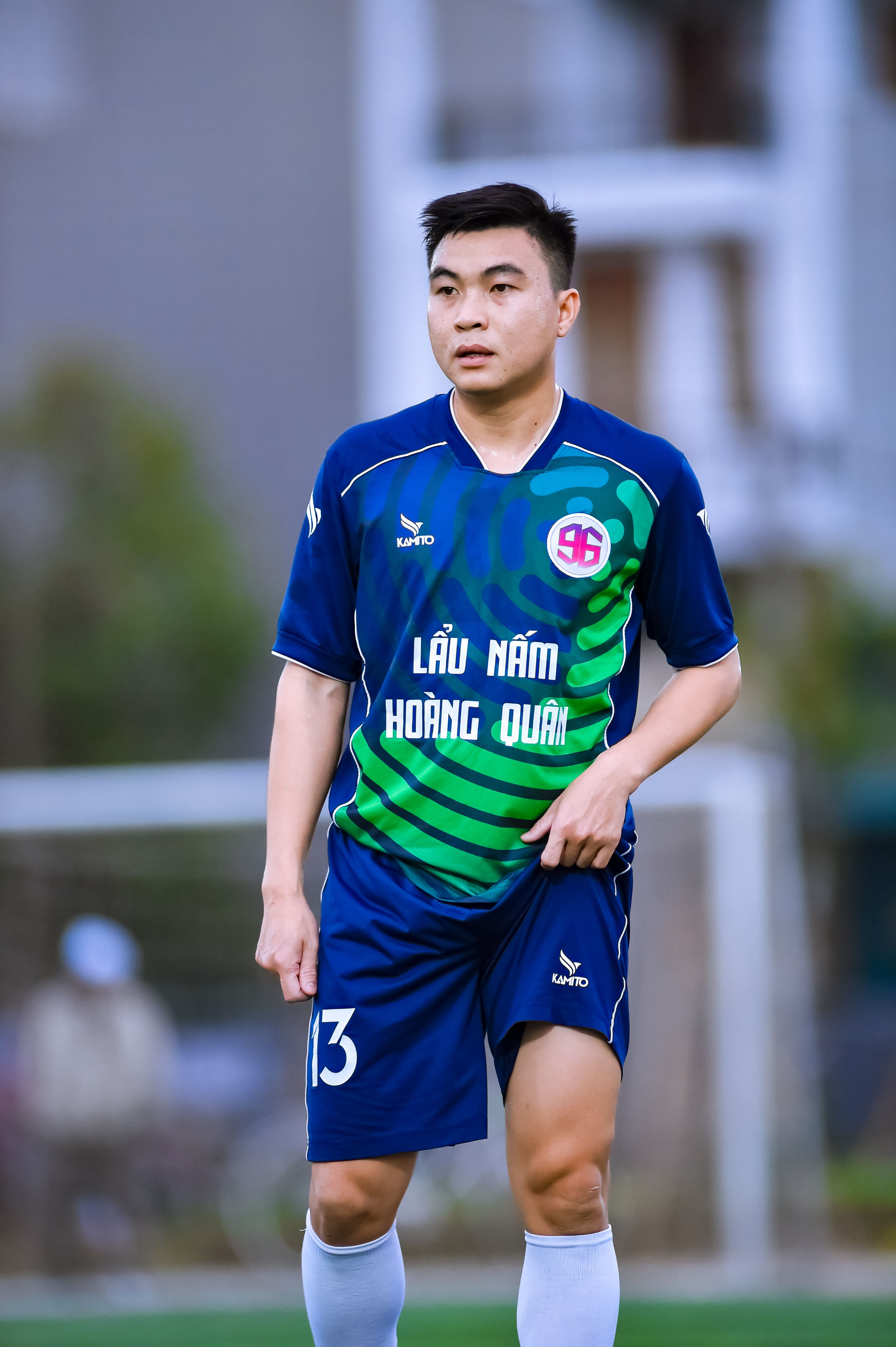 A young Vietnamese football player in motion on a field in Hà Nội.