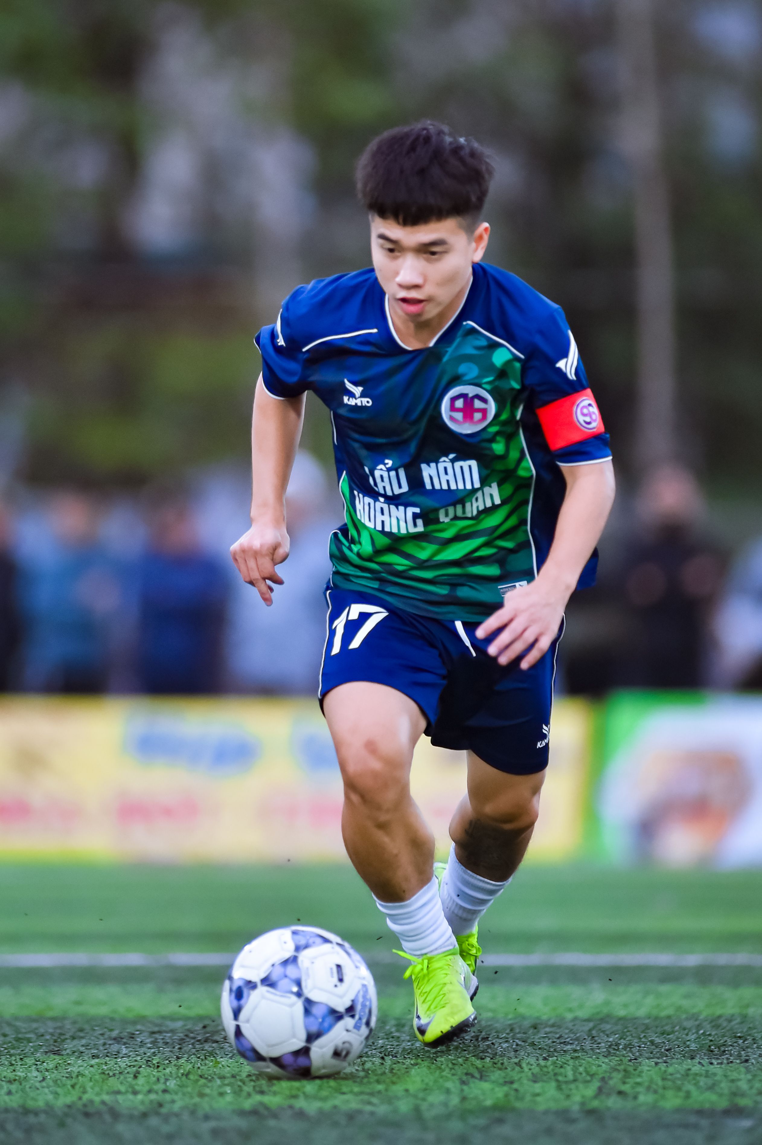 Football player in mid-action during a match in Hanoi, Vietnam.