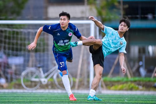 Free Two football players in action during a game at a sports field in Hanoi, Vietnam. Stock Photo