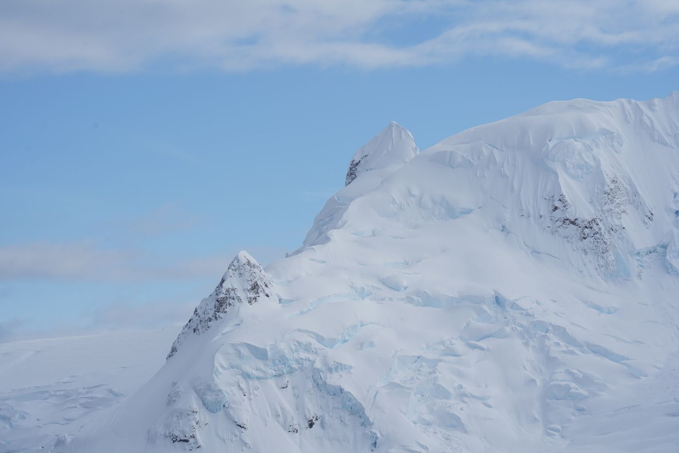Snow-covered mountains in Antarctica under a clear blue sky