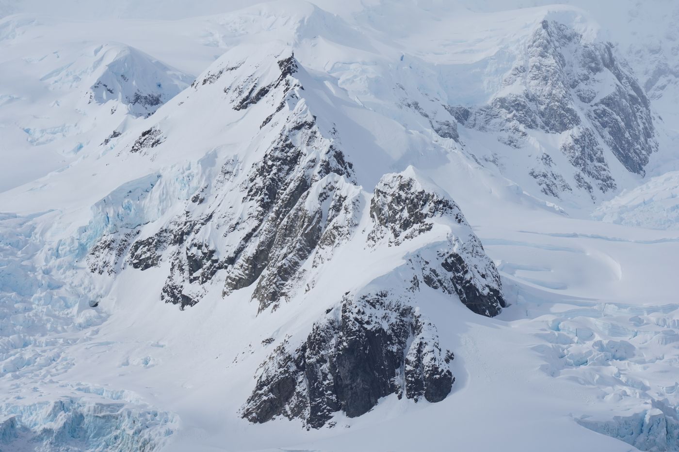 An aerial view of snow-covered mountain ridges in Antarctica