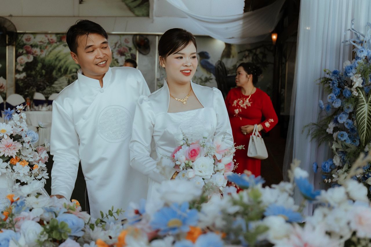 bride and groom in elegant attire surrounded by colorful flowers at th