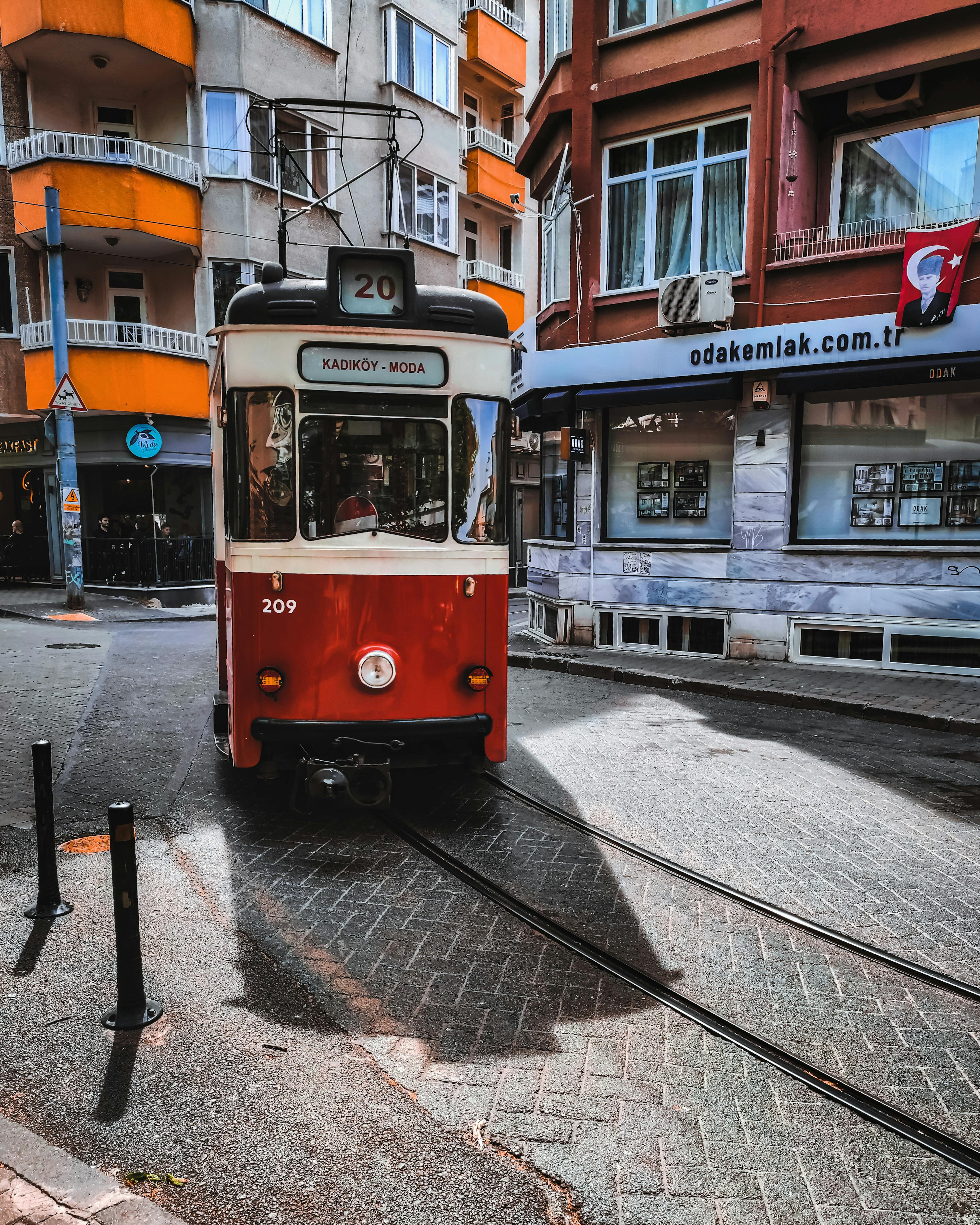 Bezpłatne Urokliwy czerwony tramwaj przemierzający ulice Kadıköy w Stambule, zachwycający lokalną architekturą i żywą atmosferą. Zdjęcie z galerii