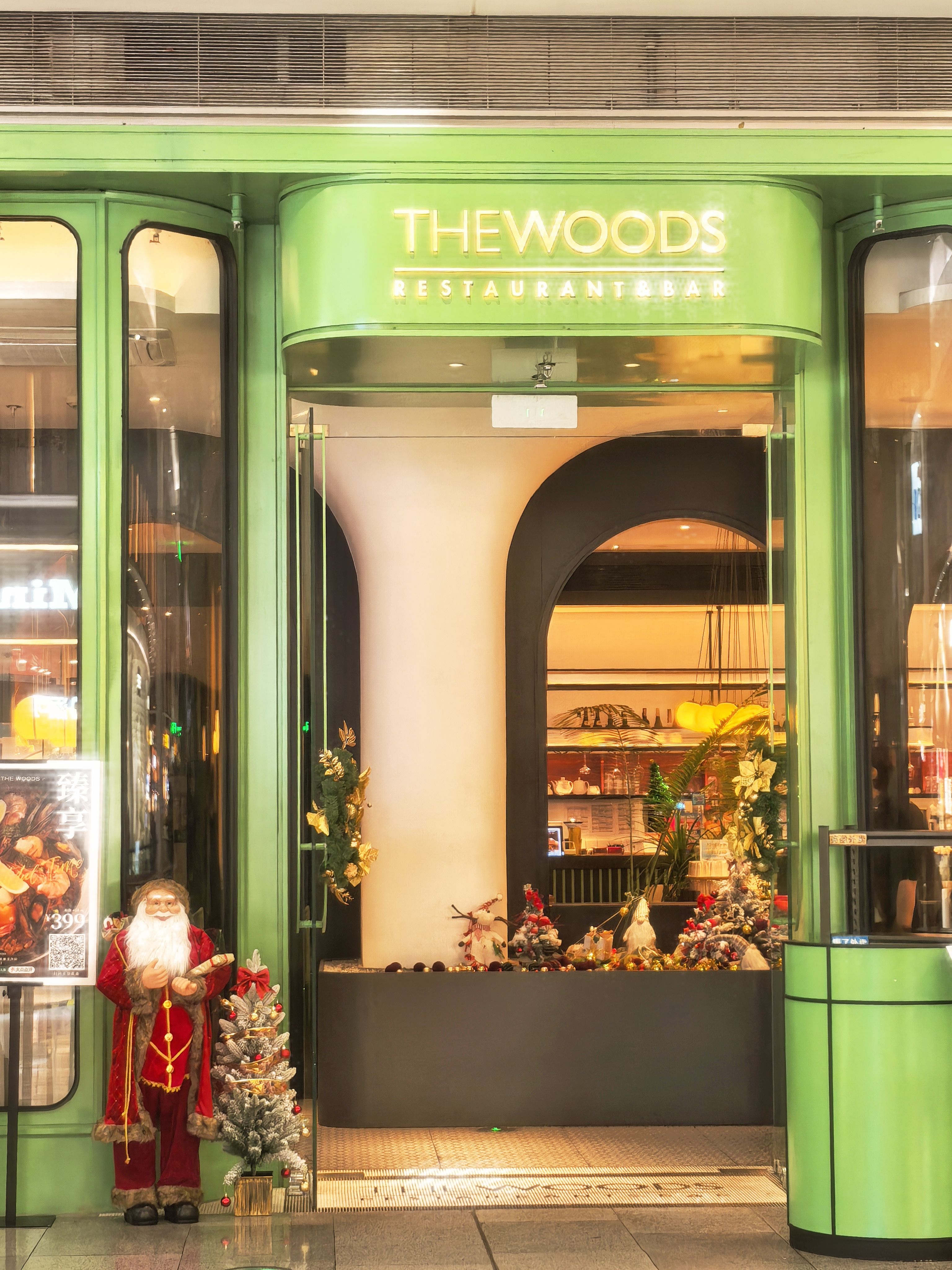 A warmly lit restaurant entrance decorated for Christmas with Santa and festive elements.