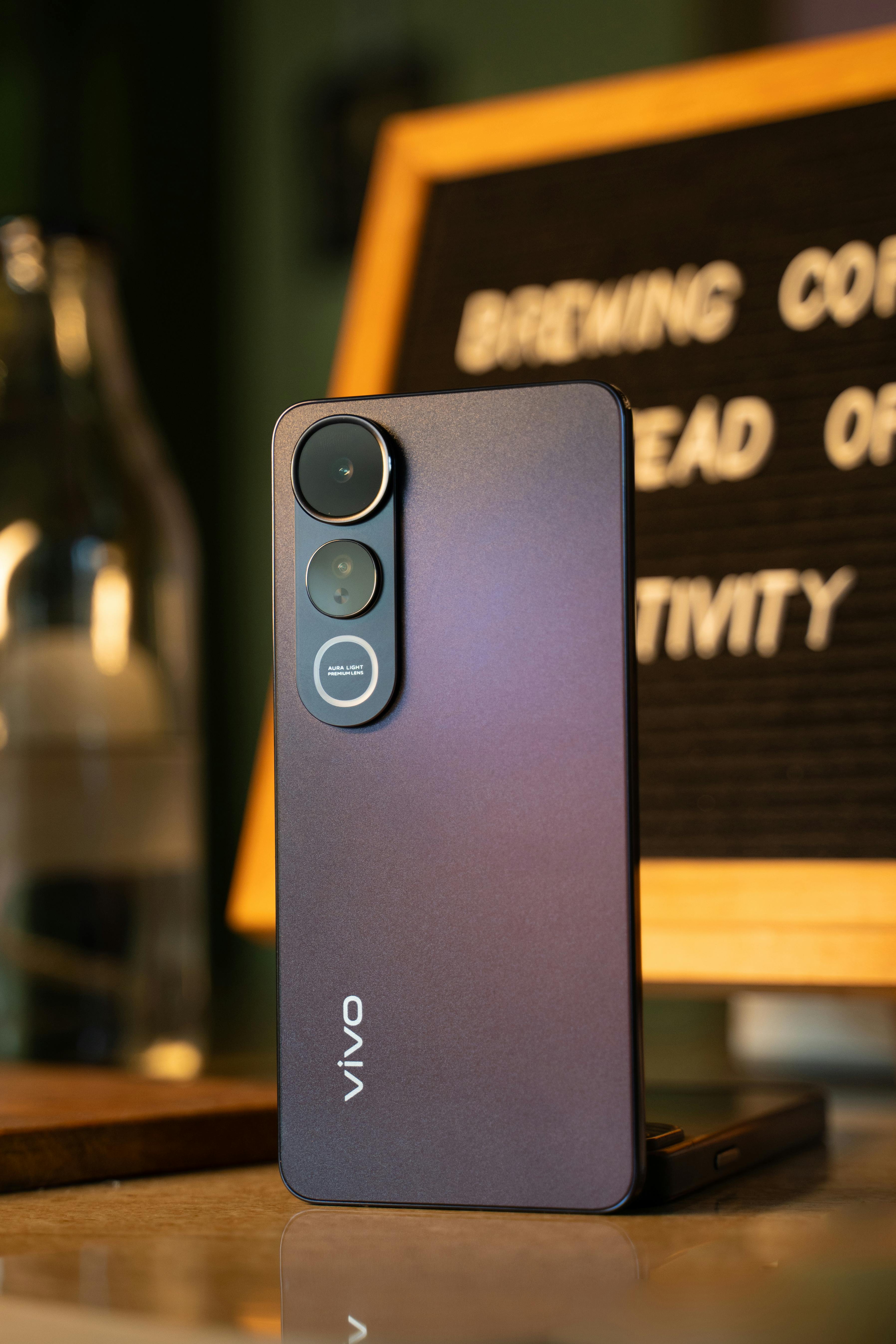 Free Close-up of a smartphone on a table, with a blurred background and inspirational message. Stock Photo