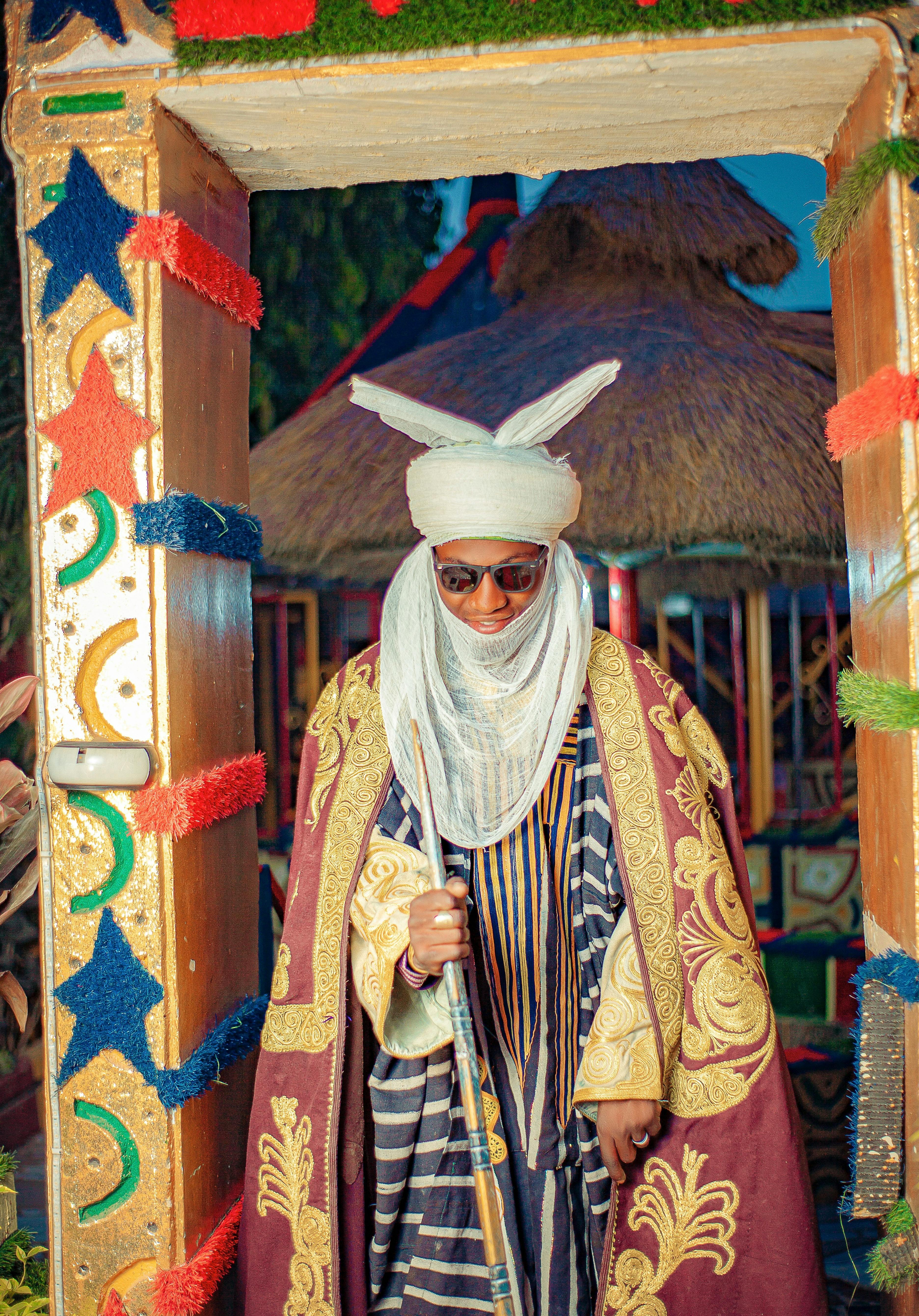 Man in vibrant African royal attire with ornate decorations.