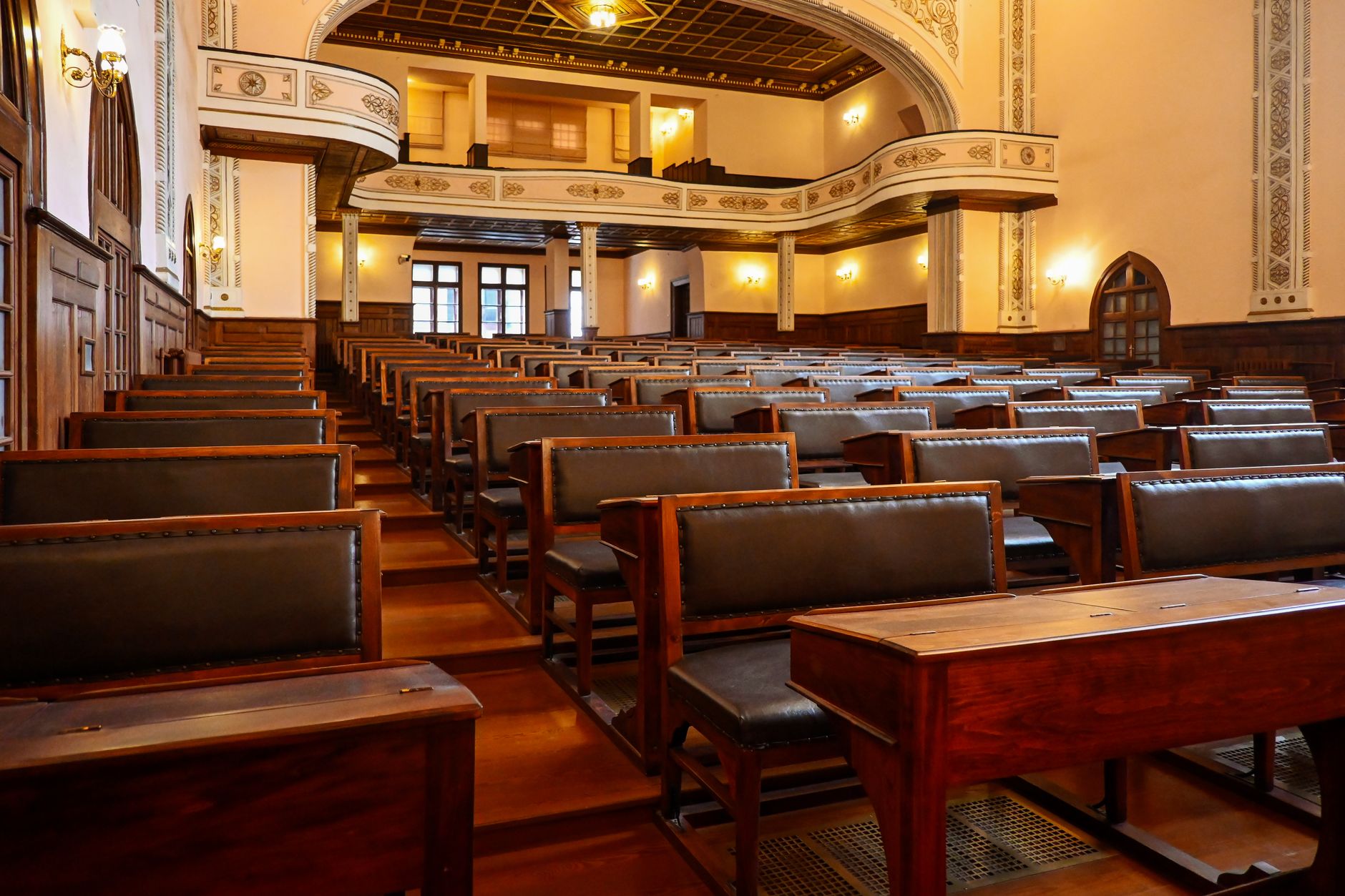 A historic lecture hall featuring wooden benches and classic architectural details, ideal for educational settings.