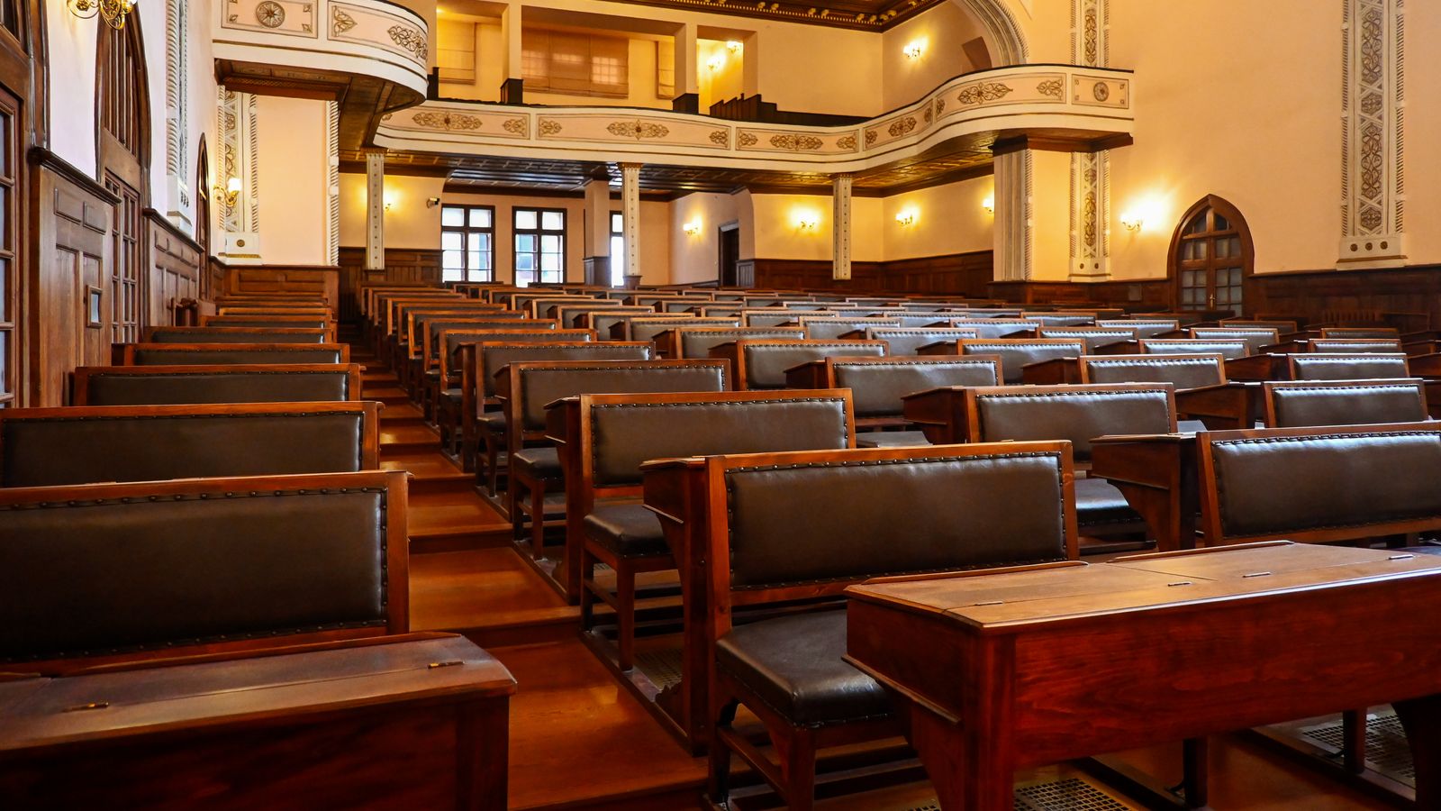 A historic lecture hall featuring wooden benches and classic architectural details, ideal for educational settings.