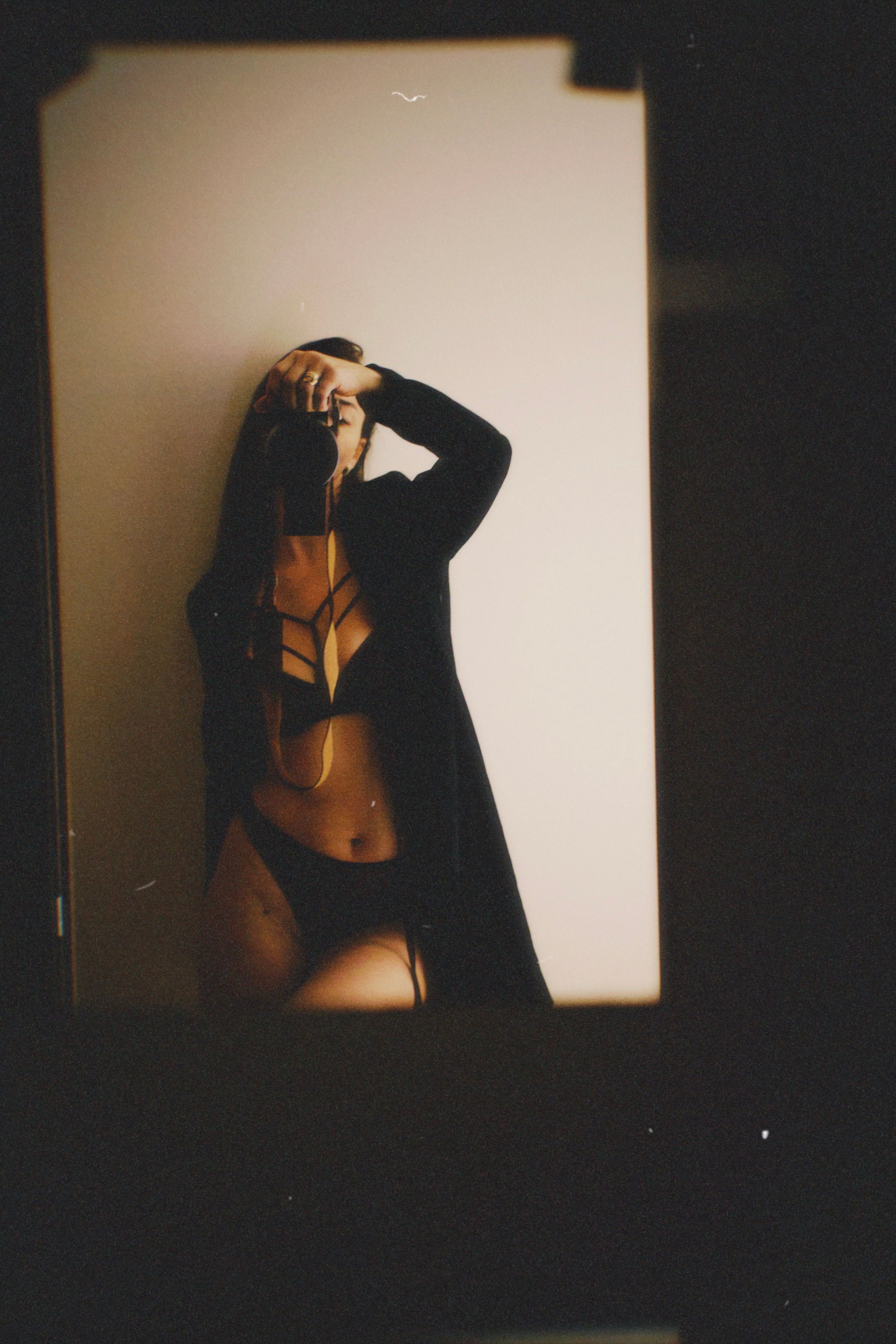 Moody and artistic self-portrait in a mirror with a film camera.
