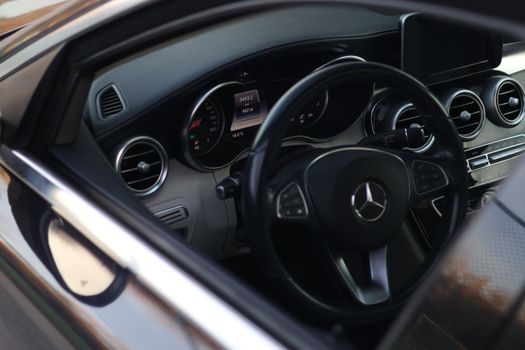 Close-up of a luxury car's interior showcasing modern dashboard and steering wheel.