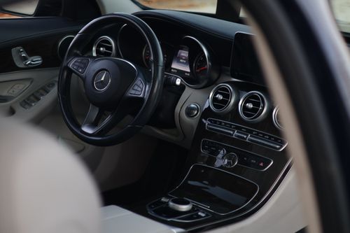 Free Close-up view of a luxury car's steering wheel and console featuring sleek design and high-end materials. Stock Photo