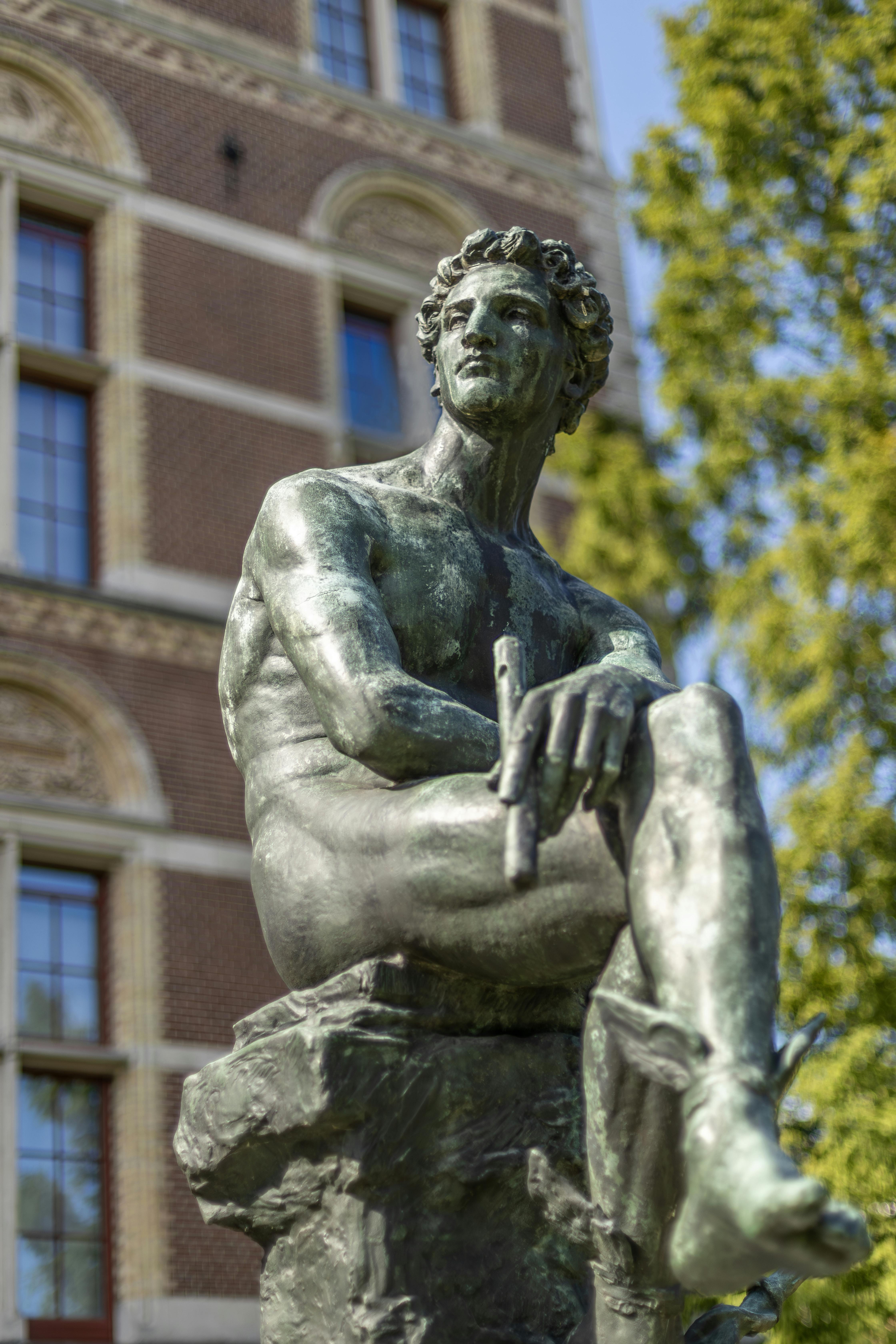Striking bronze statue at Rijksmuseum, Amsterdam in clear daylight.