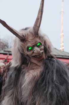 A Krampus figure with glowing eyes in a traditional Bavarian parade in Munich, Germany.
