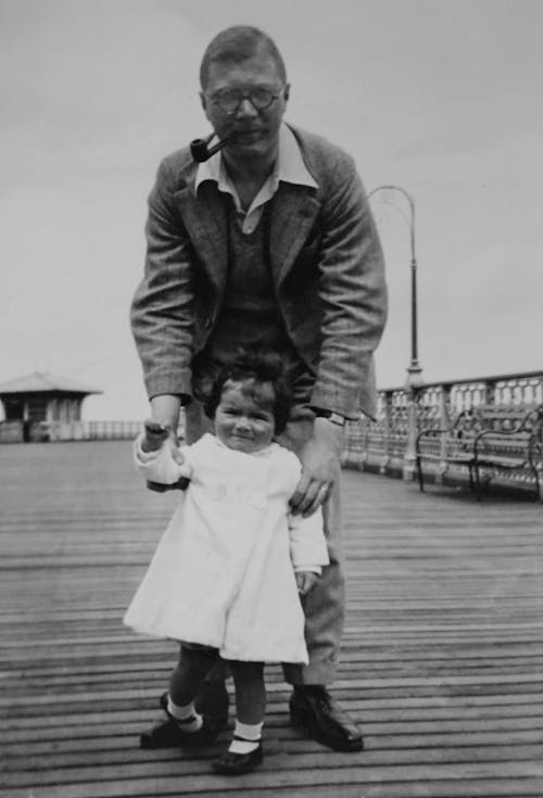 A Man Posing on Boardwalk with his Little Daughter 